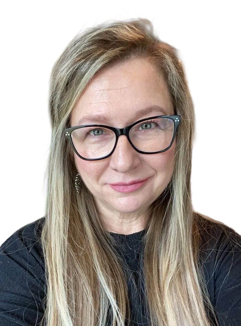 Woman with long blonde hair wearing black rectangular glasses and a black top, smiling slightly.