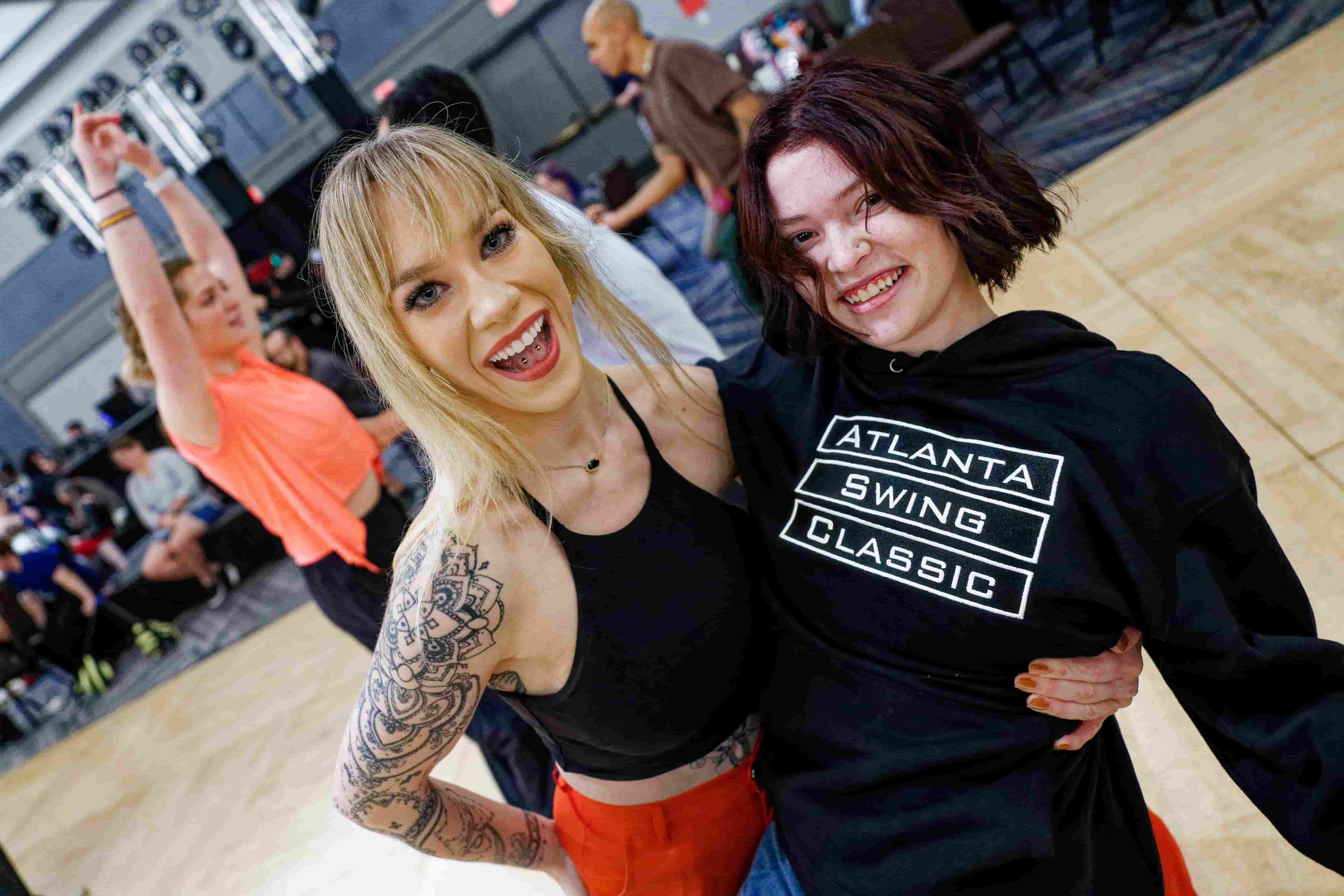 Two friends smiling and hugging each other on the dance floor 