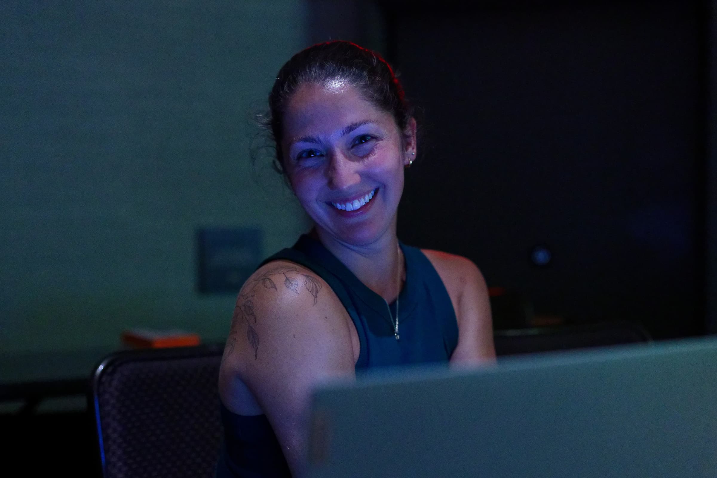 Woman smiling behind computer and booth