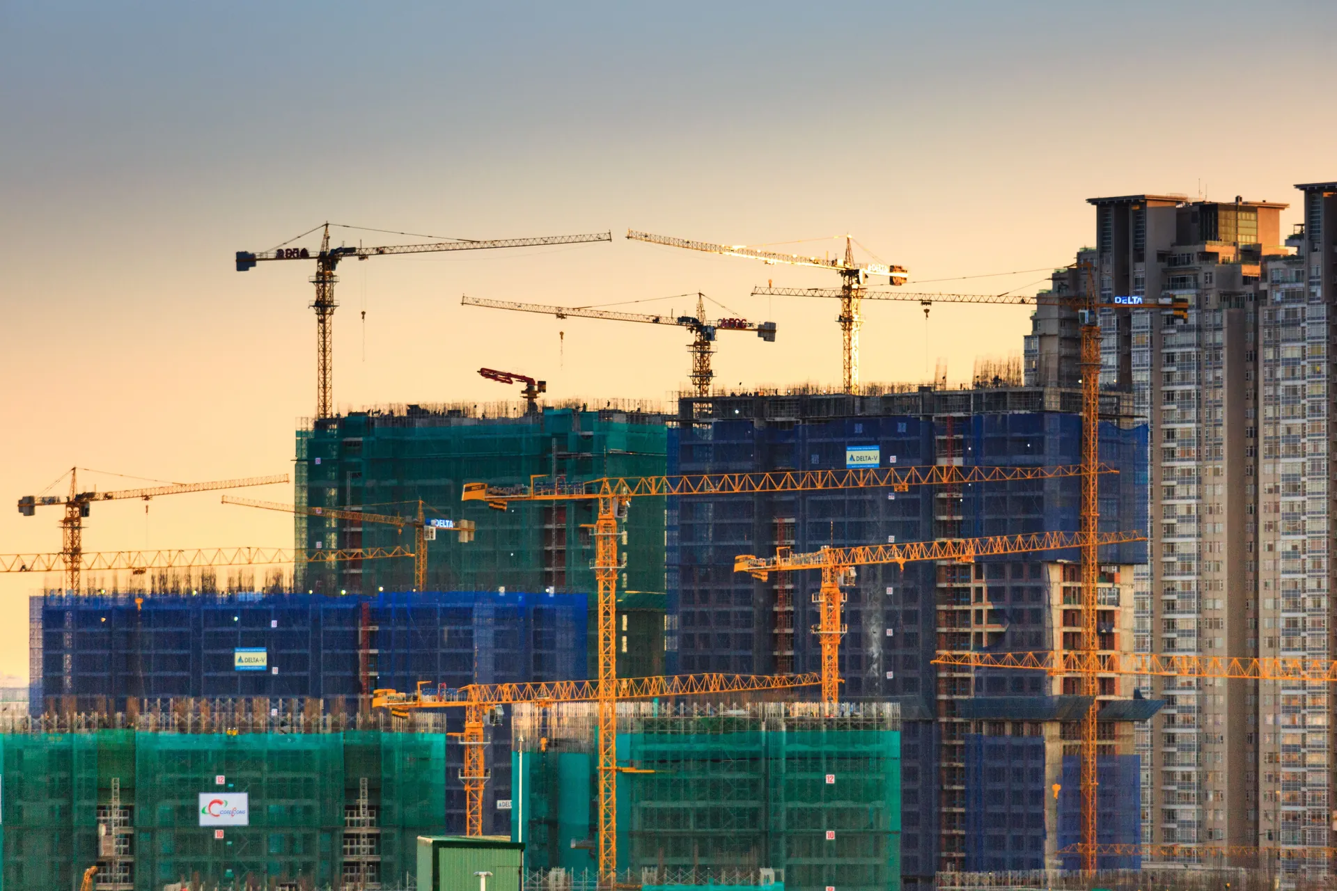 High-rise towers and cranes at sunset