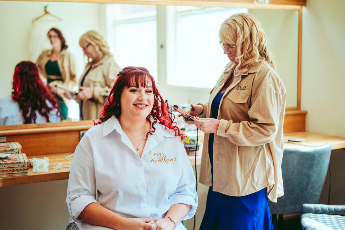Blonde hair styled in tight curls with purple and pink color accents.