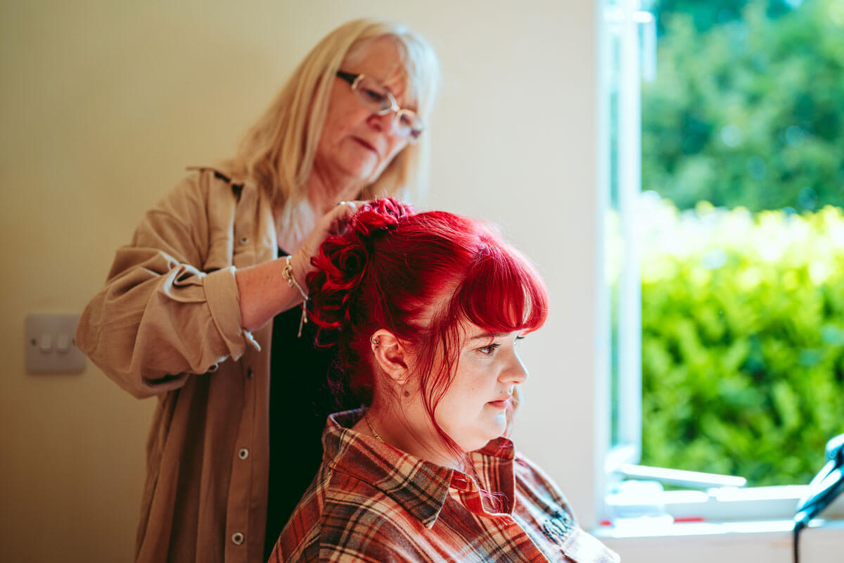 Profile of a woman with blonde hair styled in an updo adorned with delicate decorative pins.