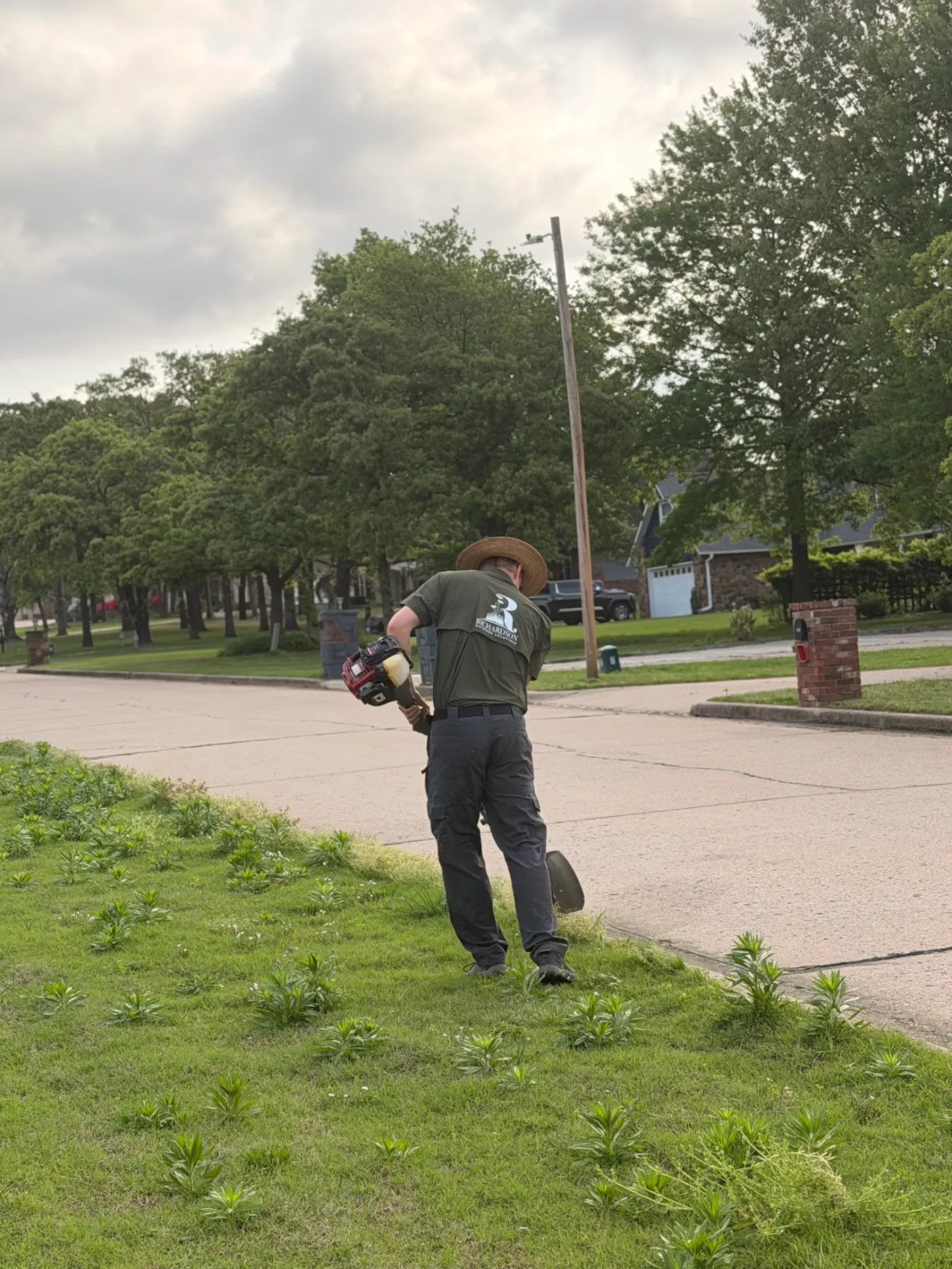 Mason Richardson string trimming along a street curb
