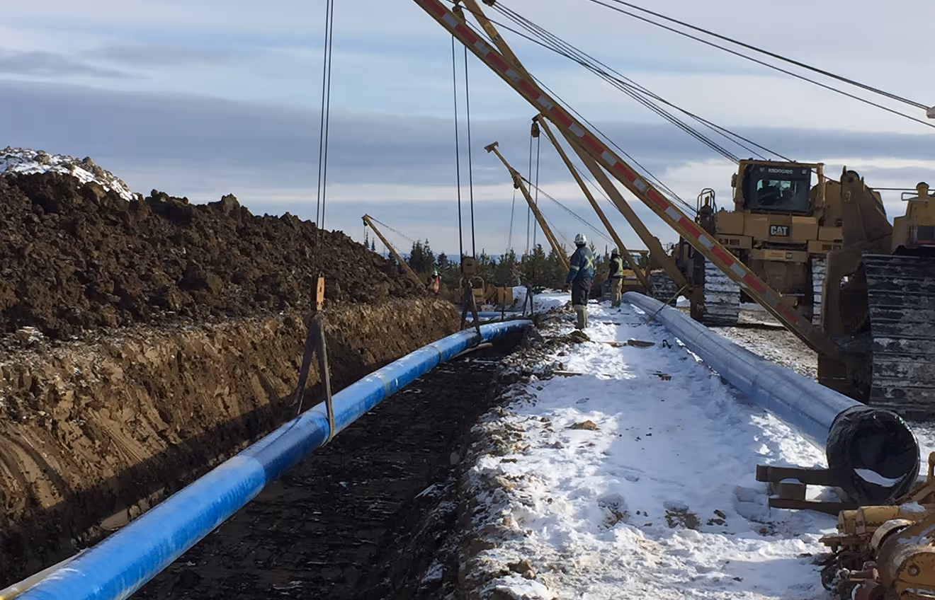 An underground pipeline installation into a long trench.