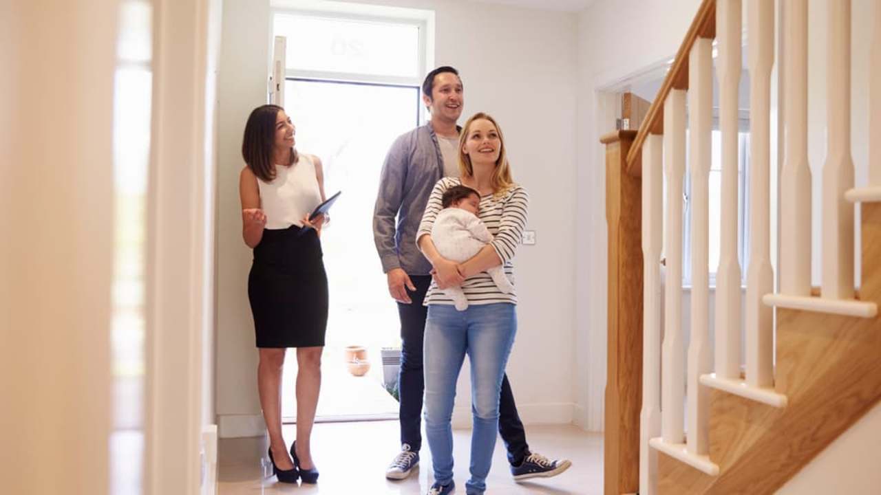 Realtor Showing Young Family Around Property For Sale