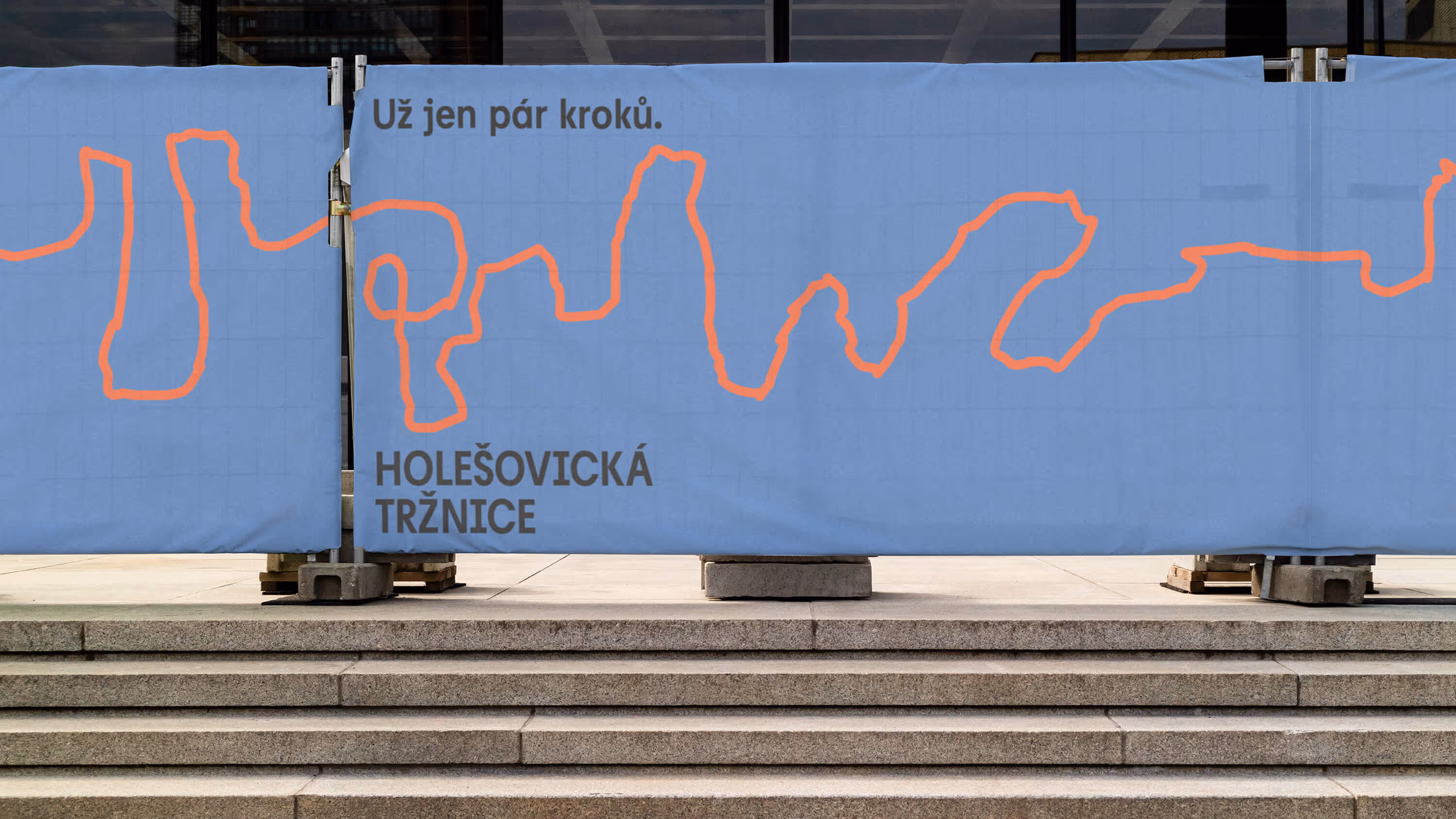 Modrá plachta s oranžovou čárou a textem Už jen pár kroků, Holešovická tržnice.