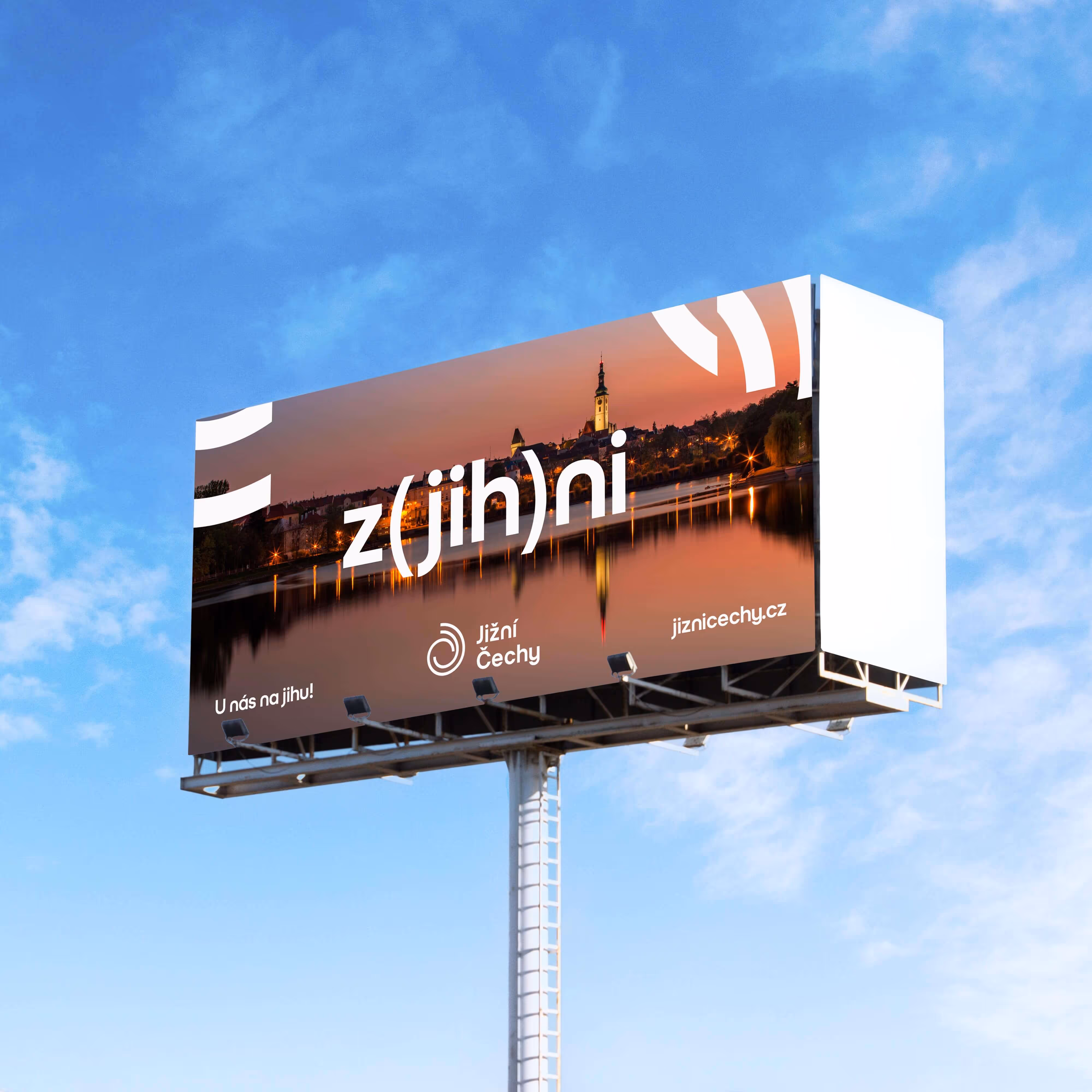 Billboard of Jižní Čechy with text z(jih)ni over a sunset town reflection on water.