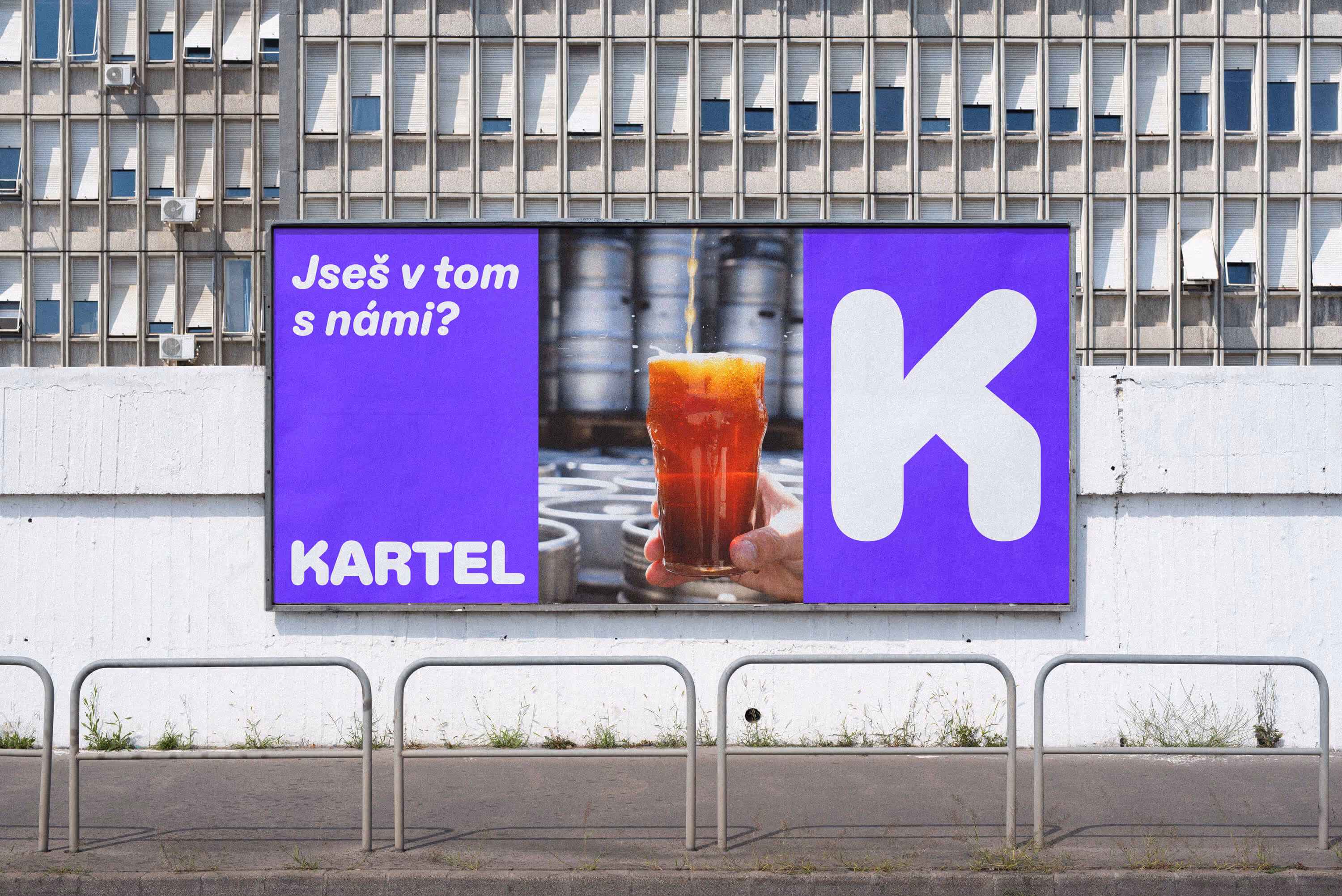 Billboard with a glass of dark beer being poured and text 'Jseš v tom s námi? KARTEL'.