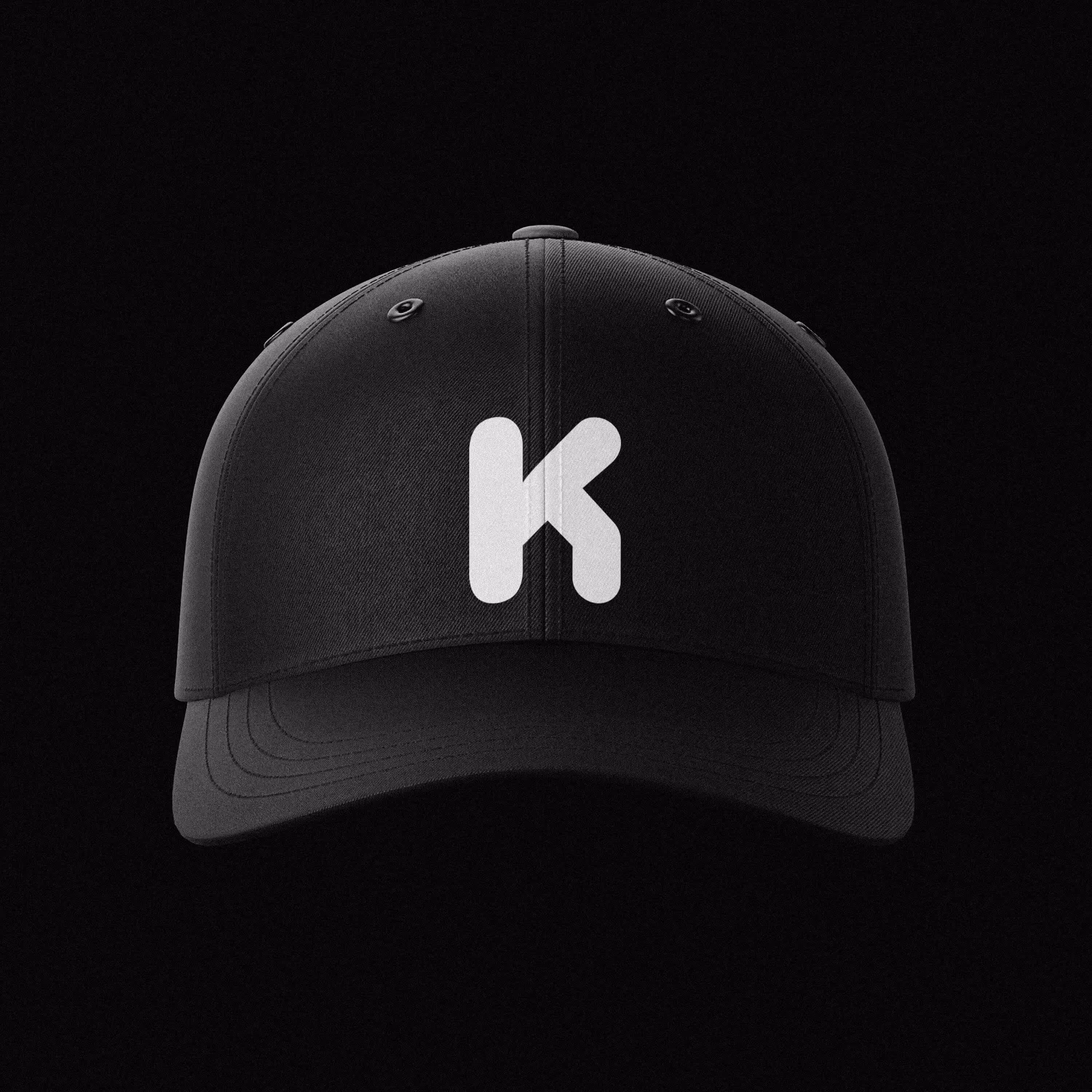 Černá kšiltovka s bílým písmenem K uprostřed.