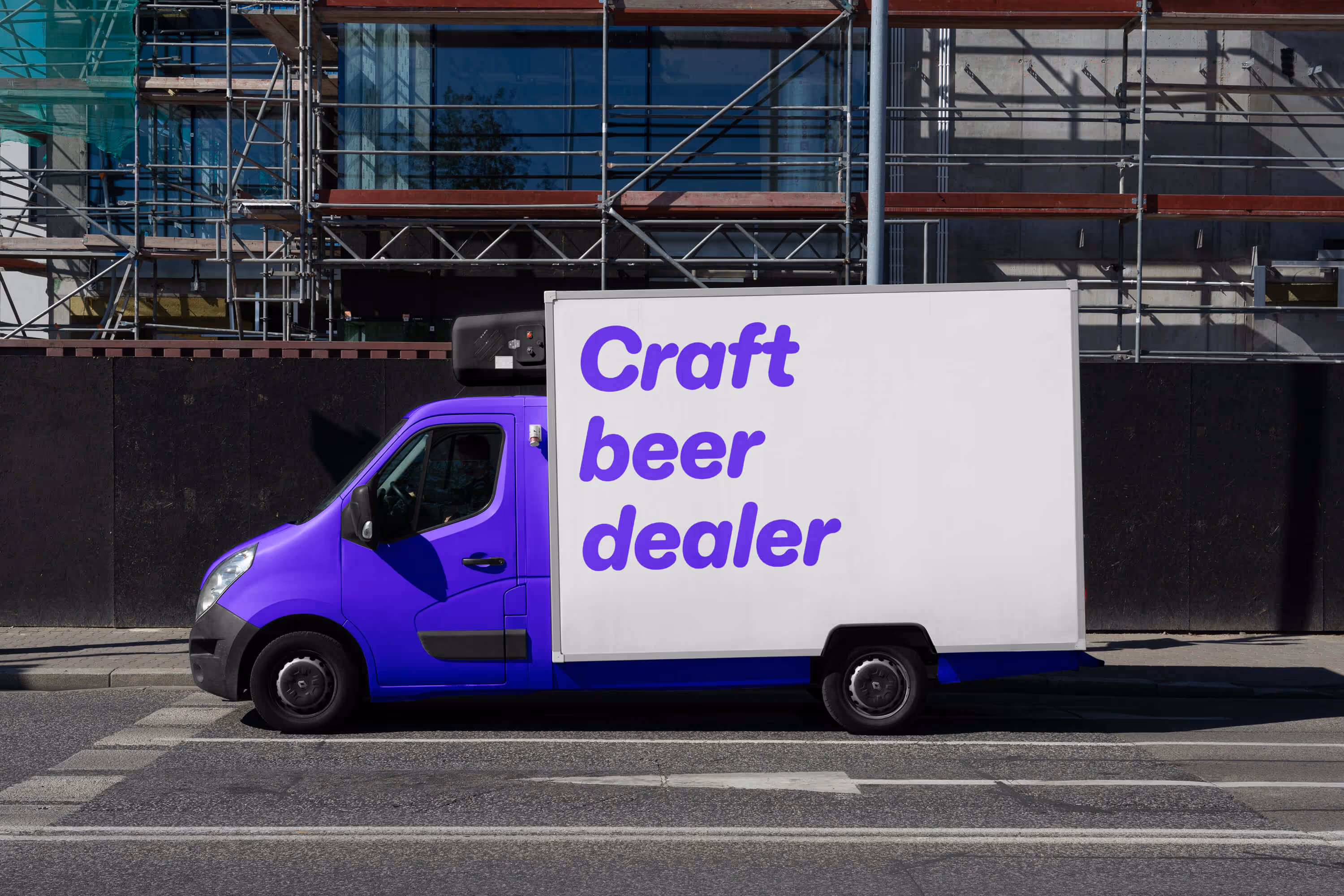 Modrý dodávkový vůz s bílou stěnou s nápisem "Craft beer dealer" zaparkovaný u chodníku.