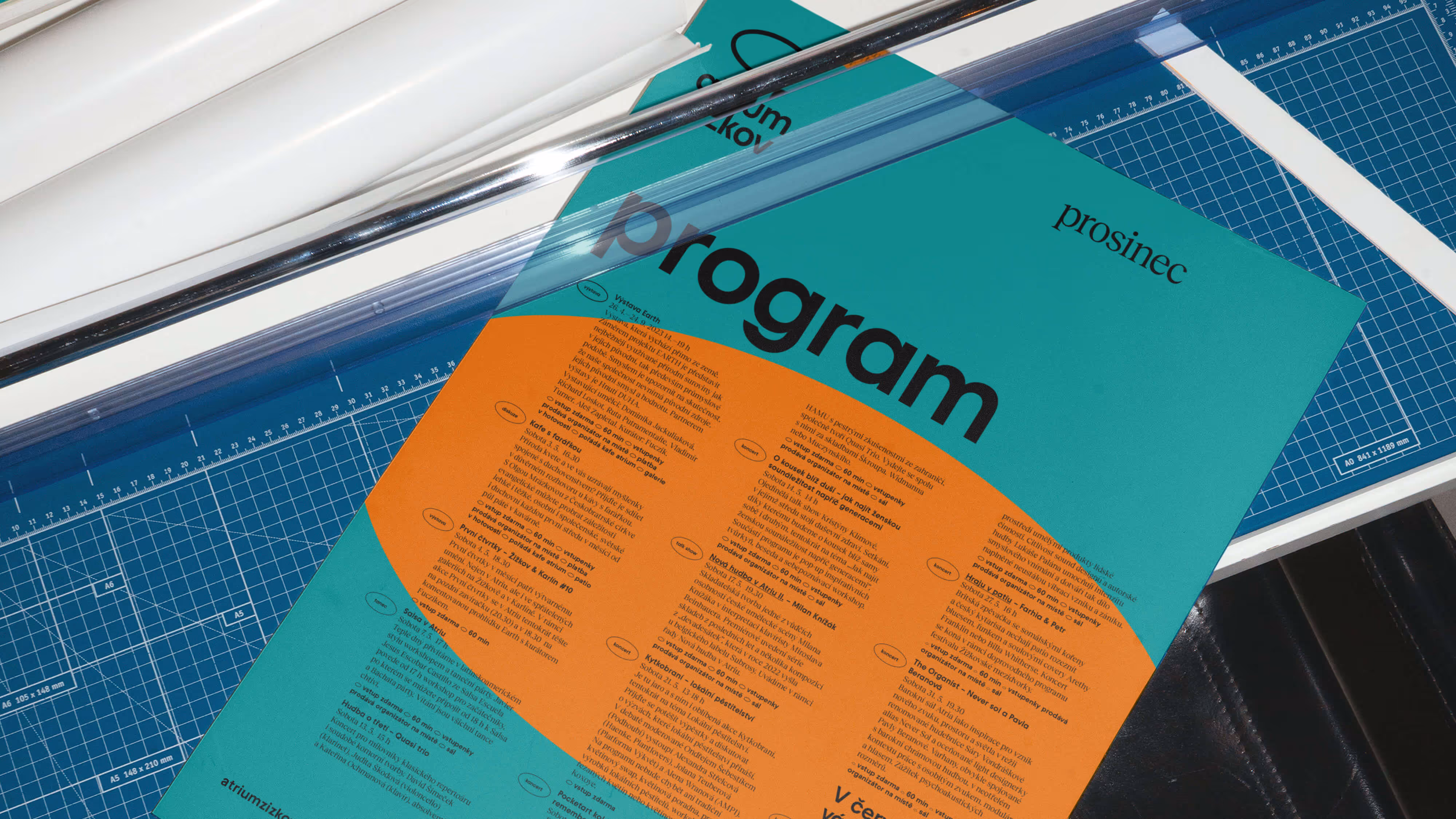 Barevný program prosince na pracovní ploše s řezačkou a podložkou na řezání papíru.