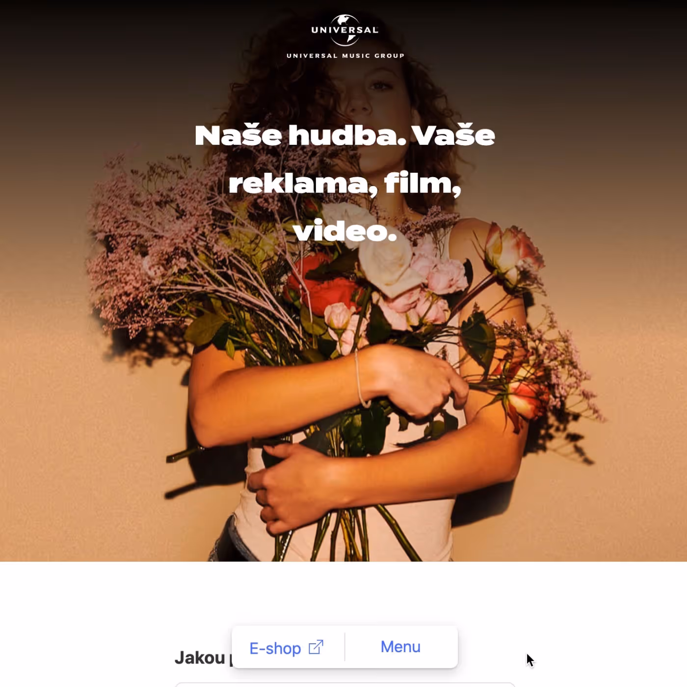 Žena s kudrnatými vlasy objímá kytici růží a dalších květin na hnědém pozadí.