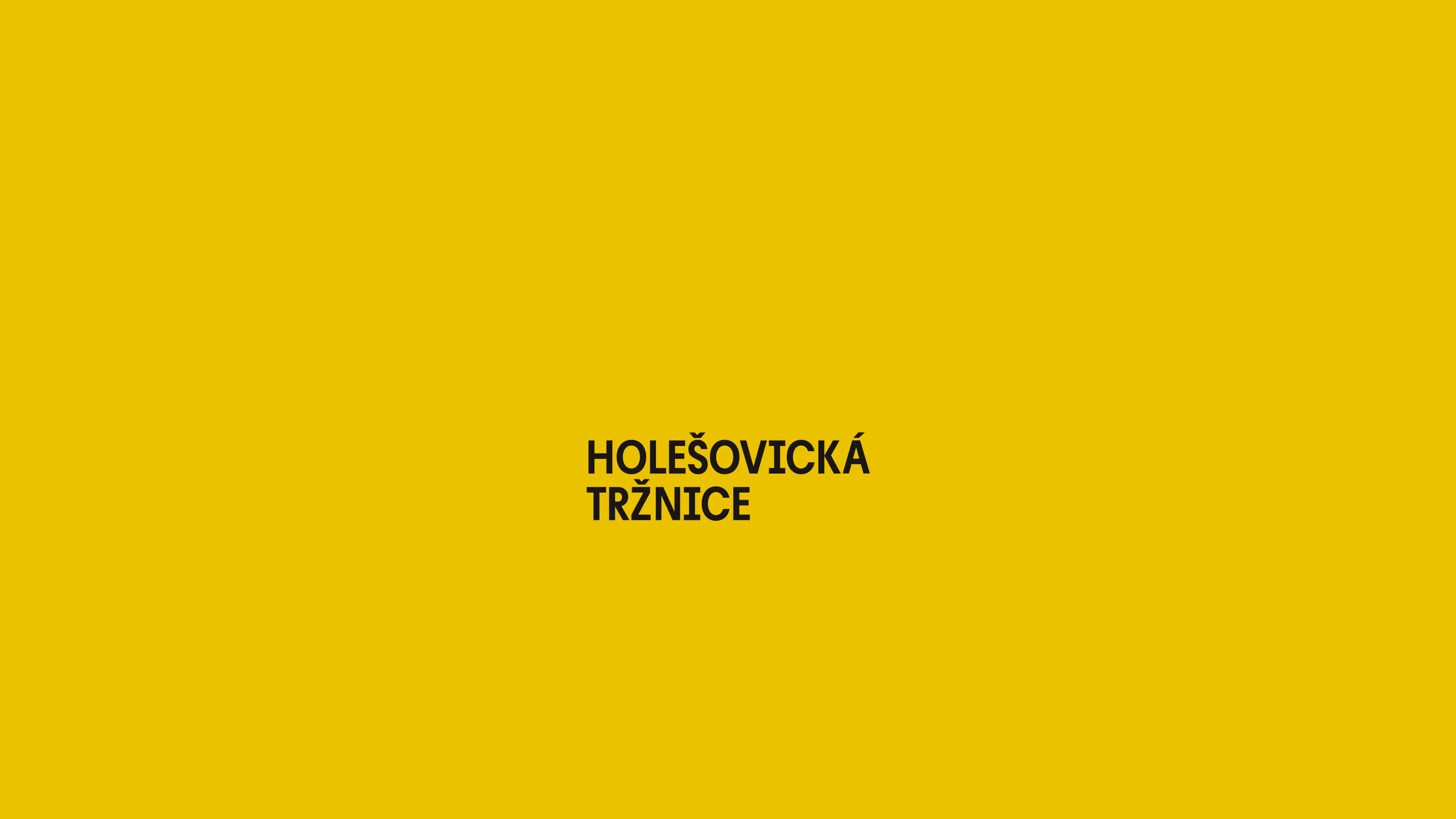 Název Holešovická tržnice na žlutém pozadí černým písmem.