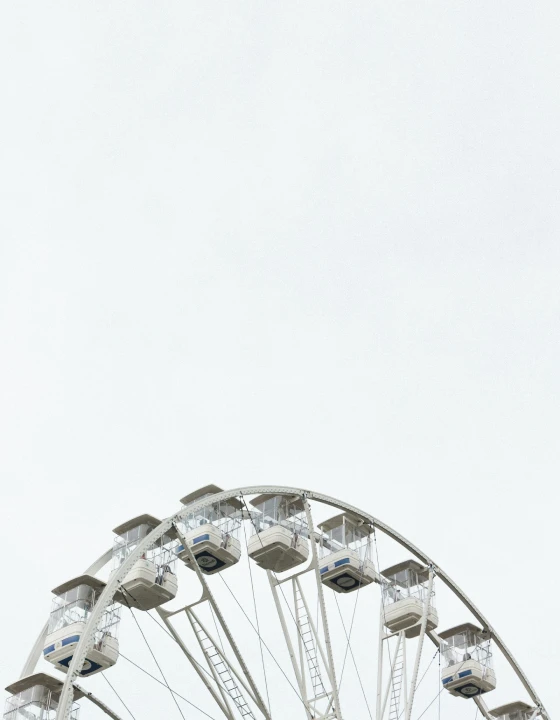 Close-up view of a Ferris wheel against a bright sky.