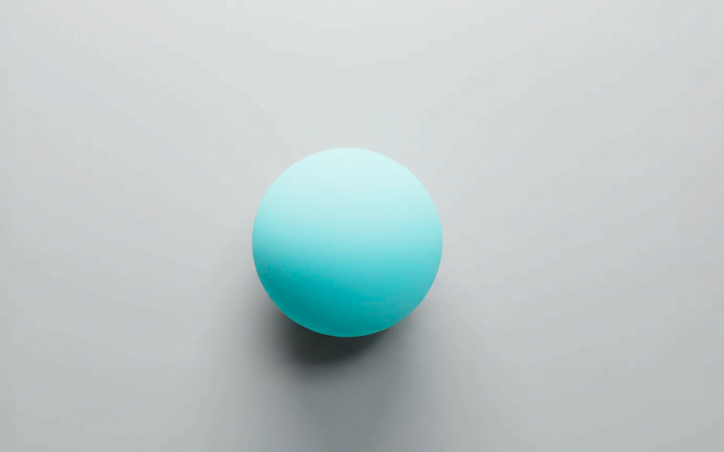 White sphere casting a soft shadow on a light gray background.