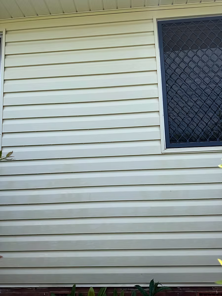 Clean house siding after professional pressure washing service by Hosed Building and Gutter