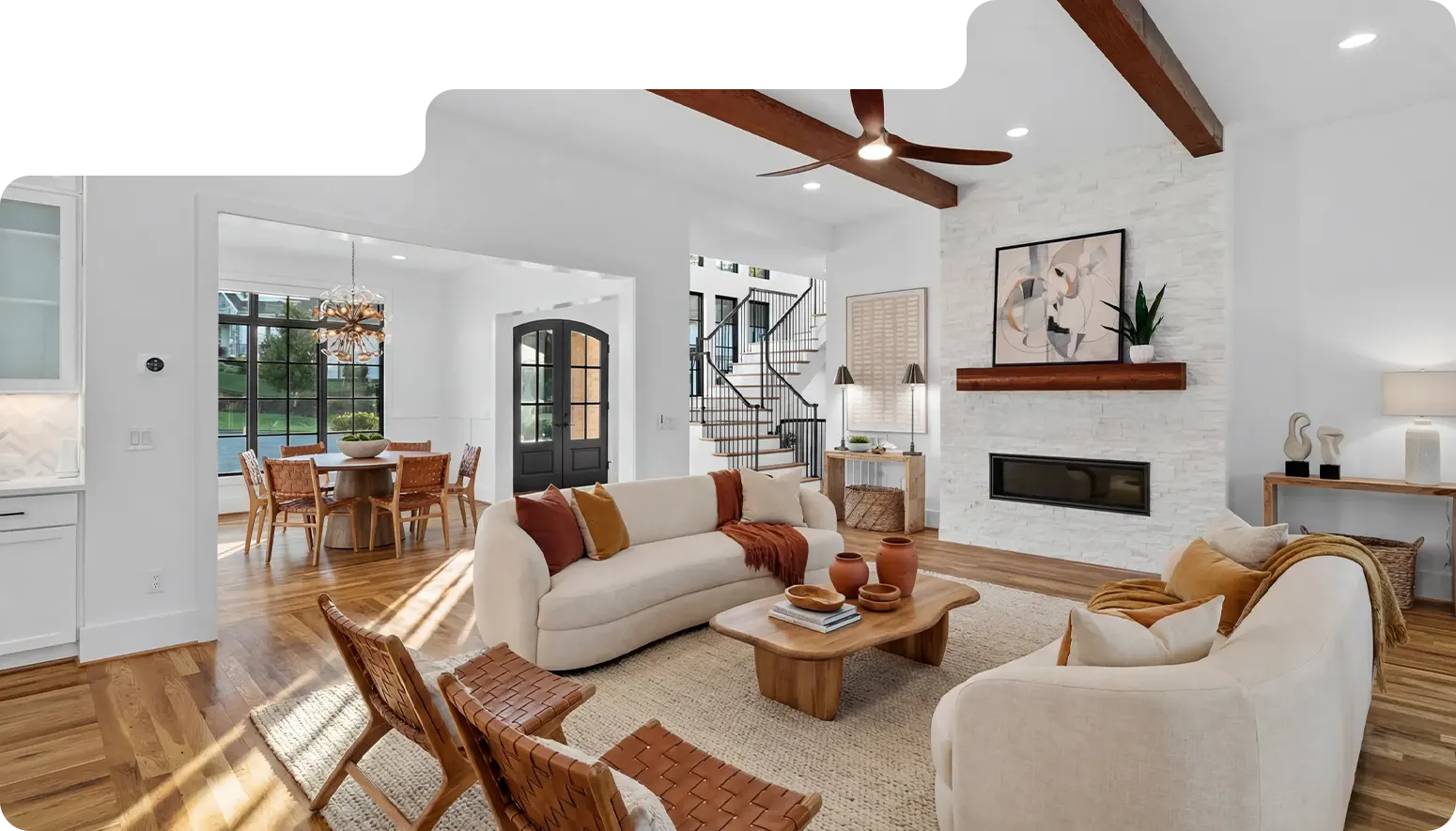 Living room with exposed beams and a stone fireplace