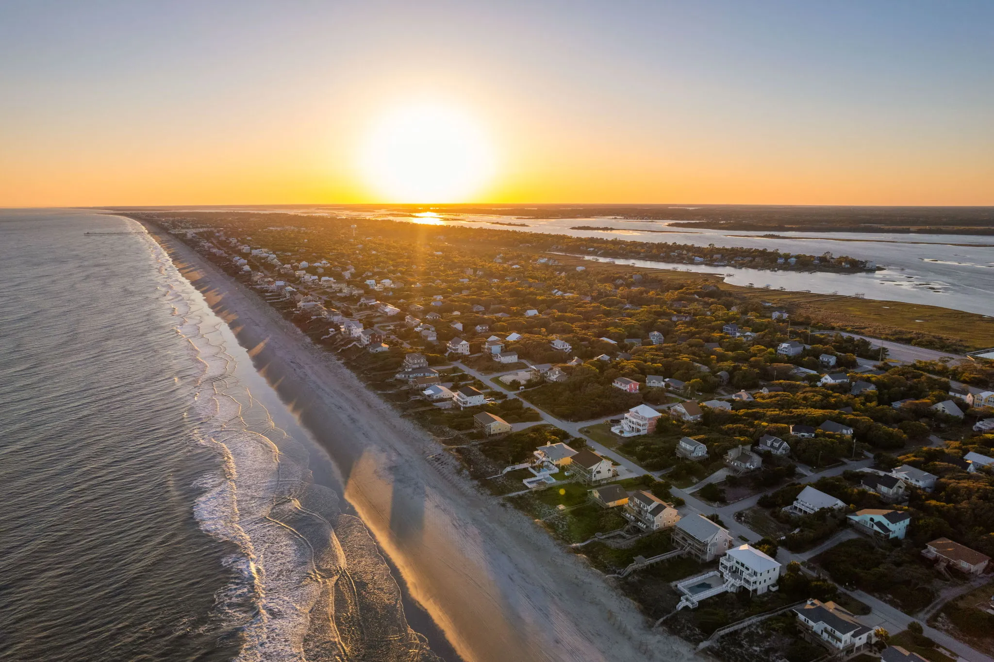 Aerial view of coastal homes and waterways at sunrise