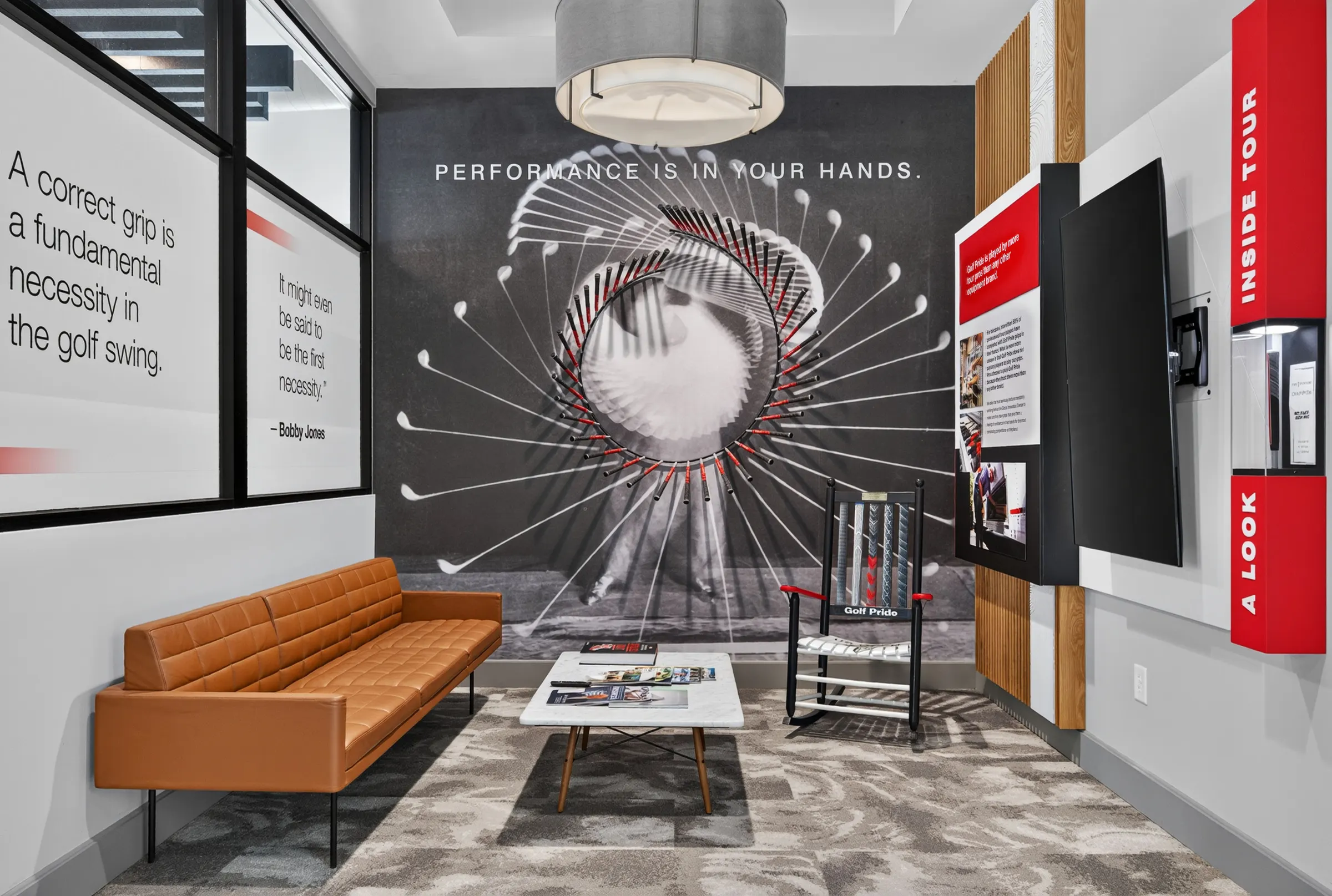 Golf Pride experience room with a circular grip display, orange bench, and branded walls