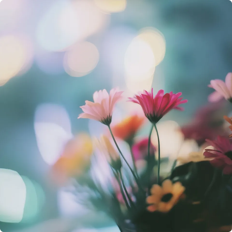 A vase filled with lots of pink and yellow flowers.