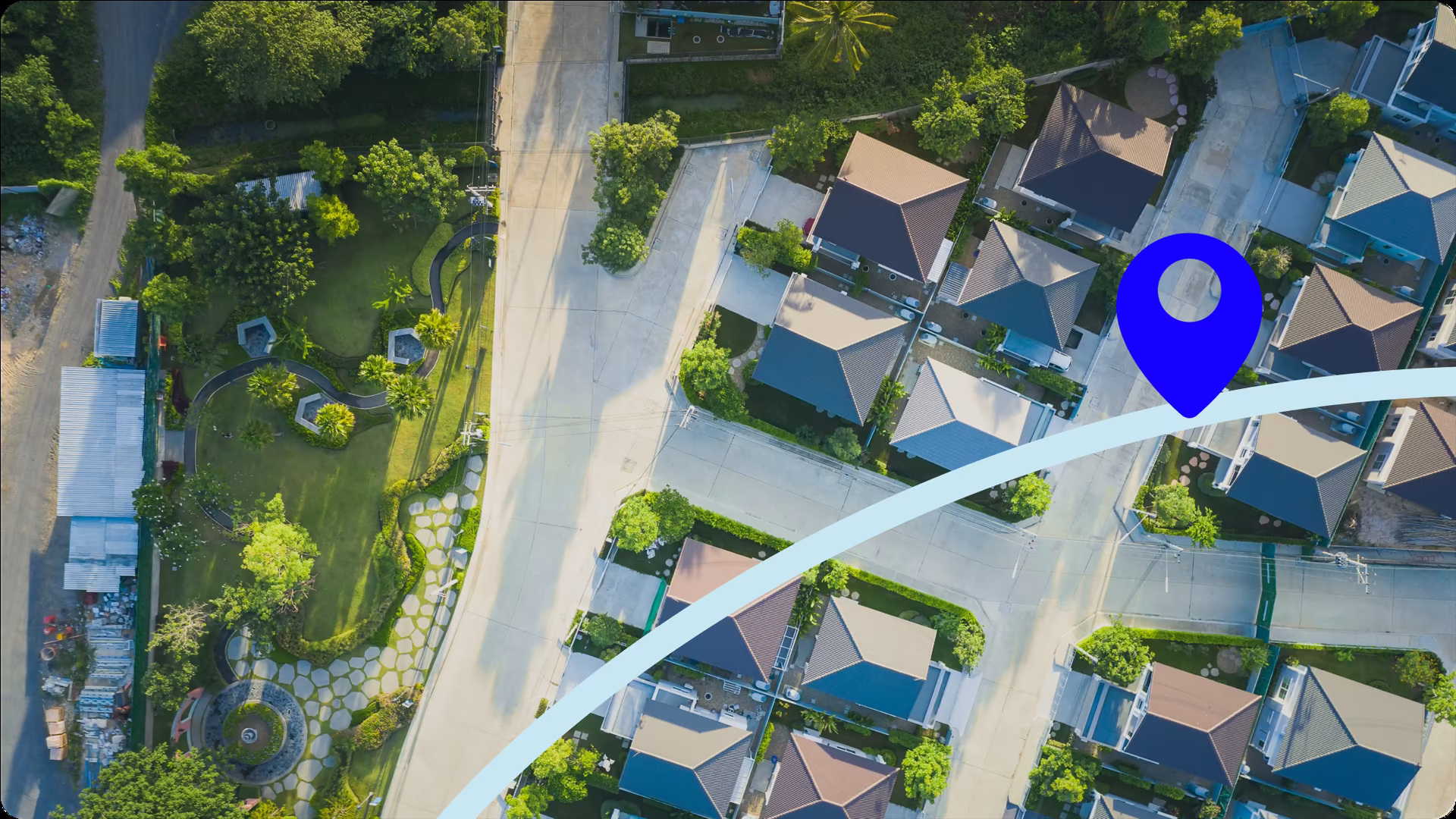 Aerial view of a residential neighbourhood with a blue route line and a location pin