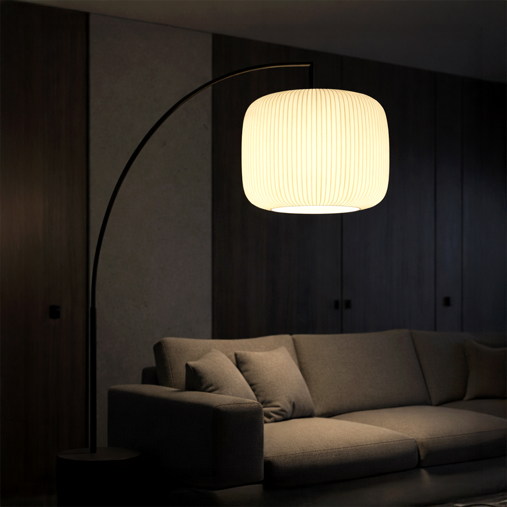 Glowing arched floor lamp hanging over a sofa in a dark room.