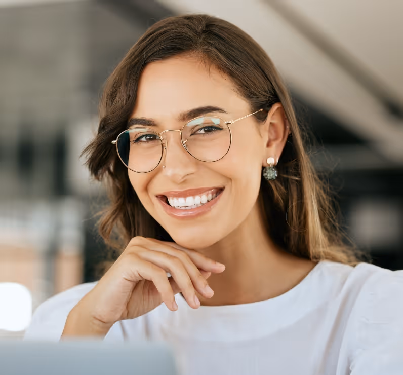 A woman wearing glasses and smiling at the camera.