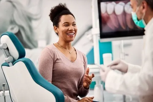 A smiling woman sitting in a dental chair.