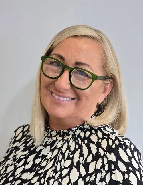 A woman wearing glasses and a black and white shirt.