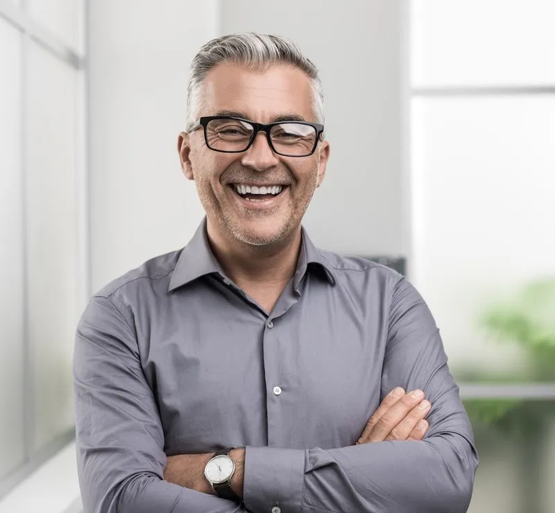 A man with glasses and a grey shirt.