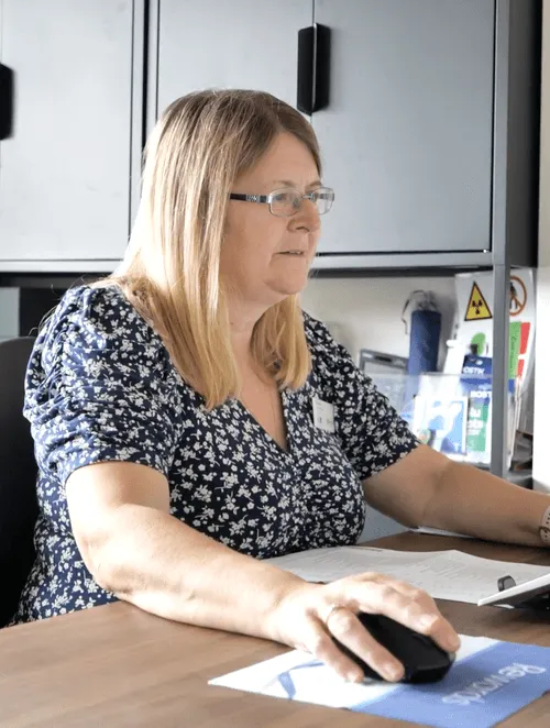 A woman sitting at a desk using a computer.