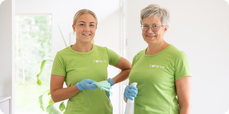 Kotiapusi Oy:n kaksi työntekijää hymyilemässä kameralle. Heillä on päällään vihreät työpaidat Kotiapusi-tekstillä.