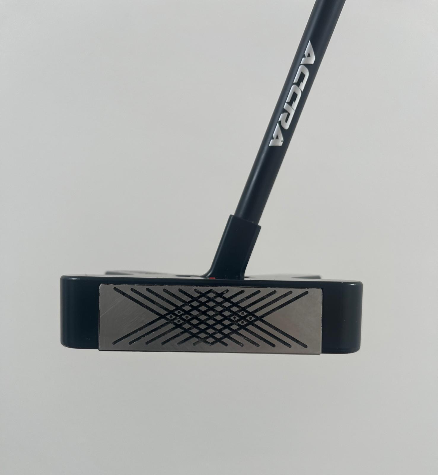 Close-up of a black golf putter head with a cross-hatch pattern on the face and ADVRA on the shaft.