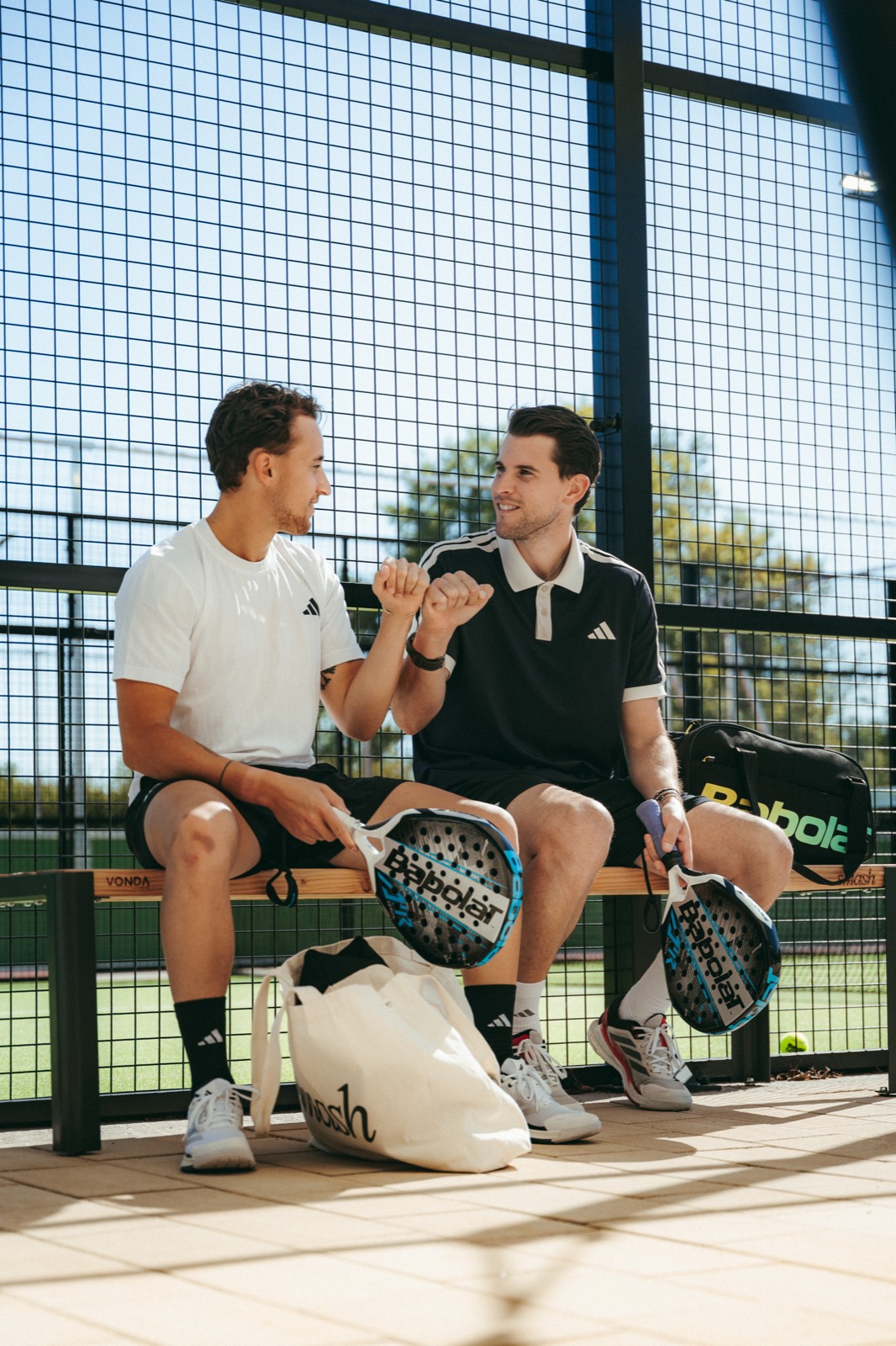 Dominic Thiem und Spielpartner auf der Bank am smash Court