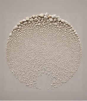 Wall art sculpture of a circular tree made of small white rounded lime stones on a beige background.