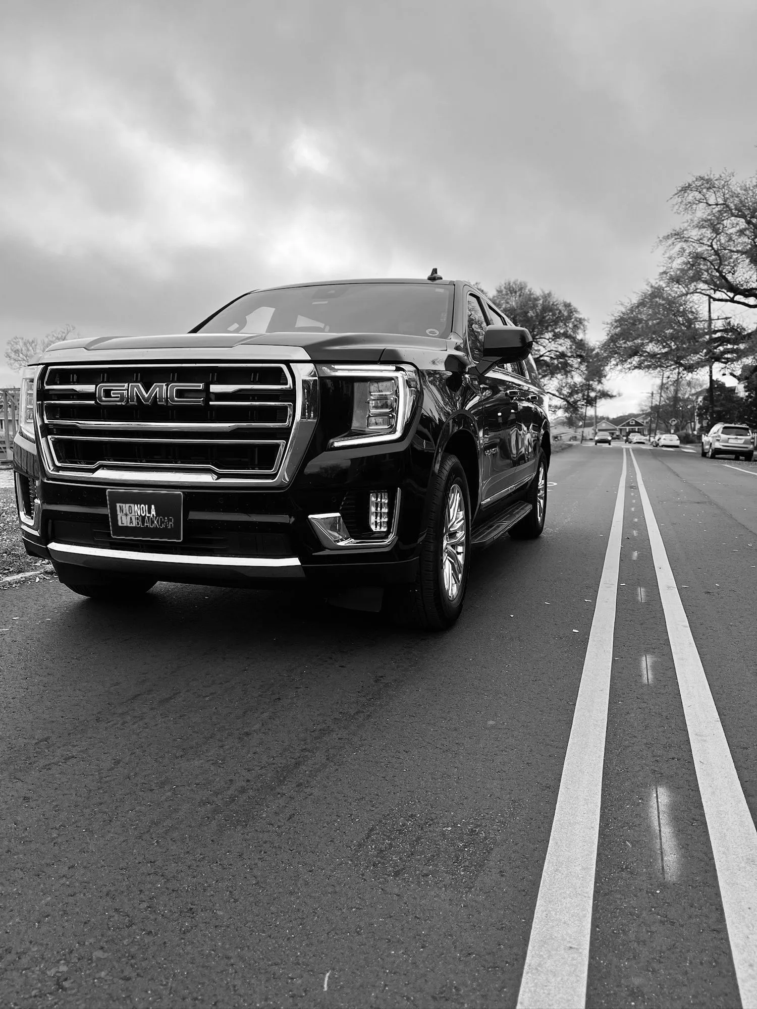 Black and white photo of a GMC Yukon on a New Orleans road