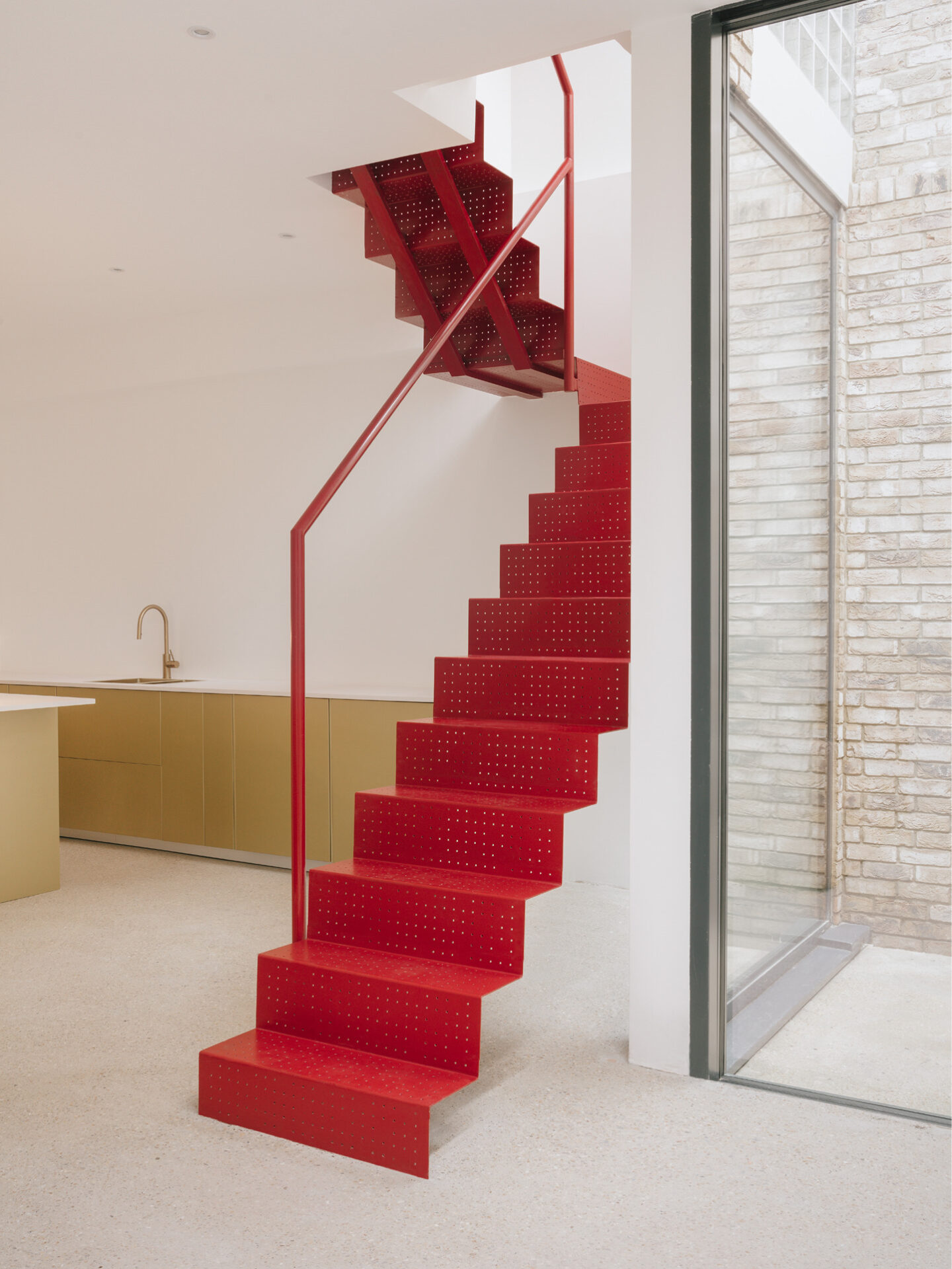 FEATURE STAIRCASE CONNECTION | A striking red perforated steel staircase at Maryland House, acting as a vertical link between floors while serving as a bold design statement.