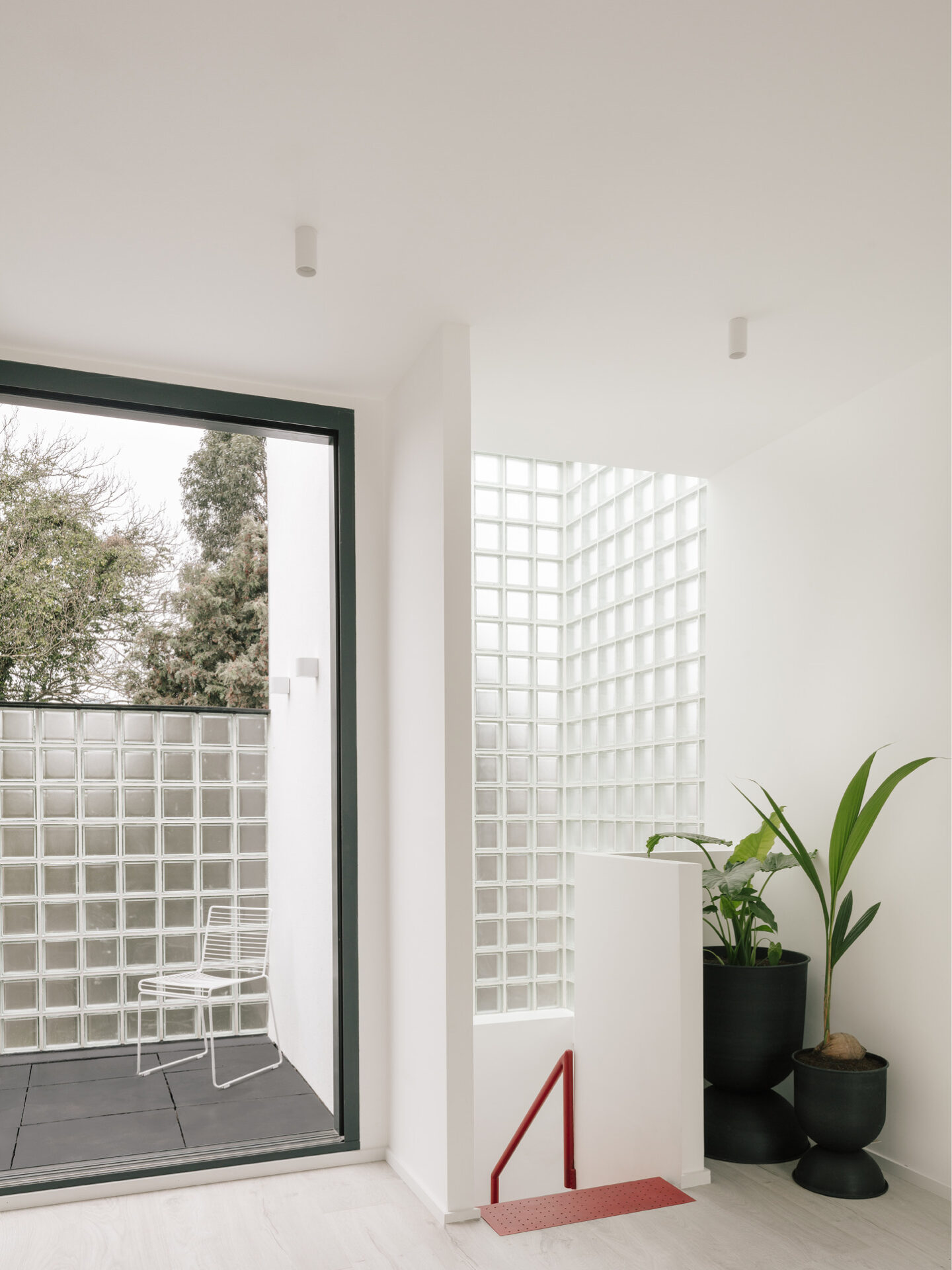 LIGHT-FILLED UPPER LANDING | Maryland House’s first-floor landing opens to a glass block wall and terrace, flooding the interior with natural light and creating a seamless connection between indoor and outdoor spaces.