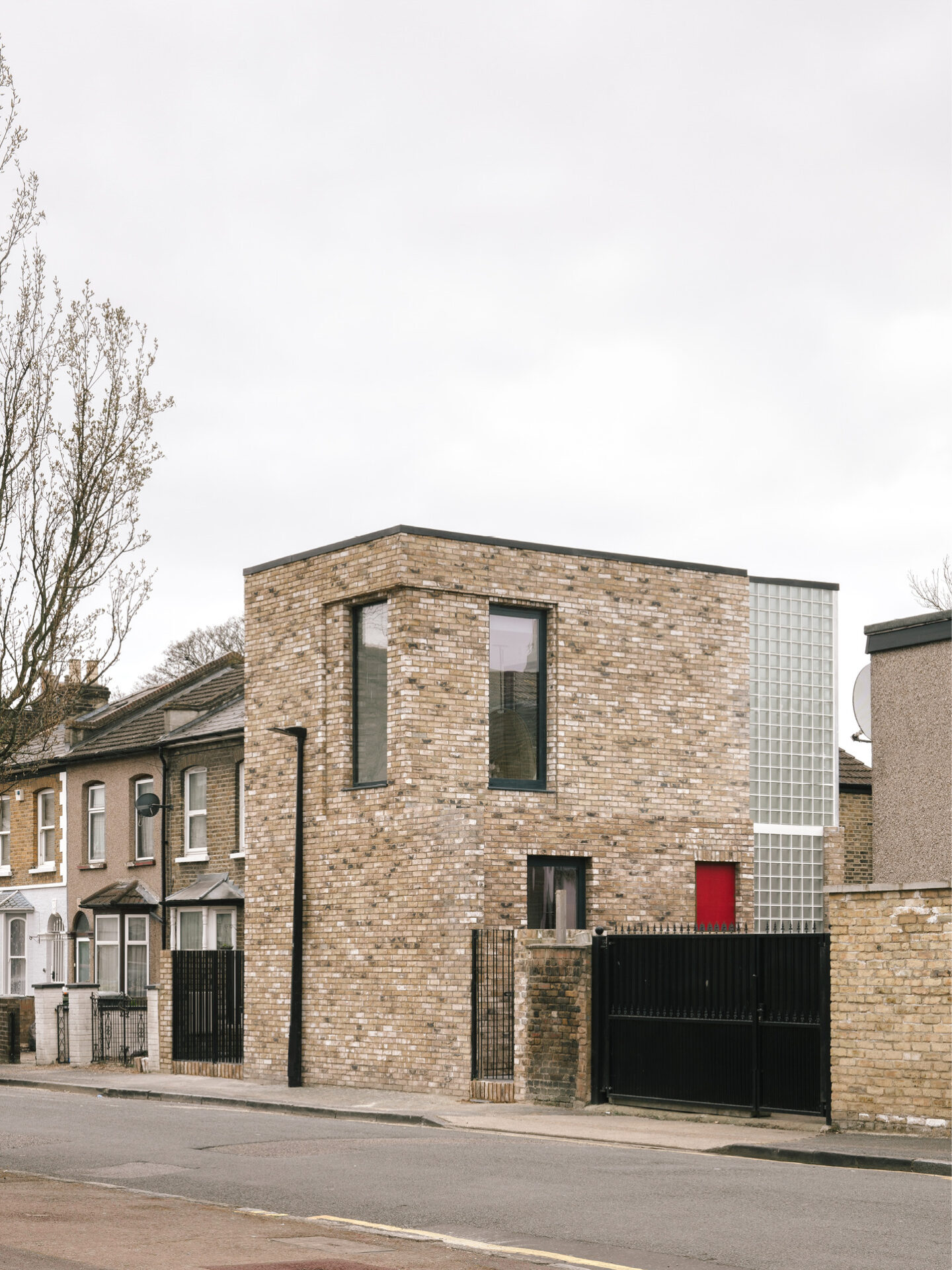 Street view | Exterior showcasing reclaimed London stock brickwork and glass block wall, presenting a striking example of infill housing architecture that complements the surrounding terraced streetscape.