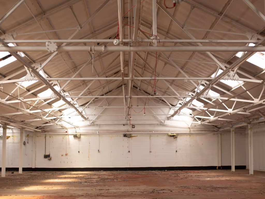 INDUSTRIAL PAST | Interior of the former light industrial unit, once home to a fabric factory and later a corrugated metal workshop, now shown in its deteriorated state.