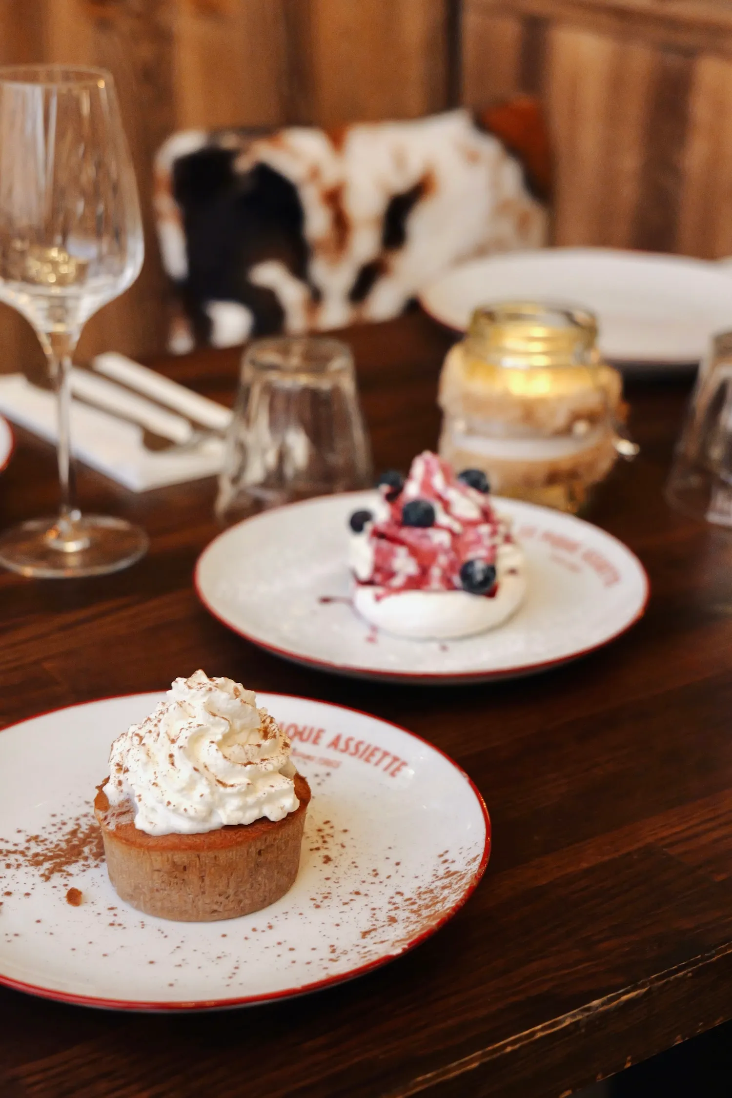 Deux desserts : une meringue aux myrtilles et un gâteau nappé de chantilly