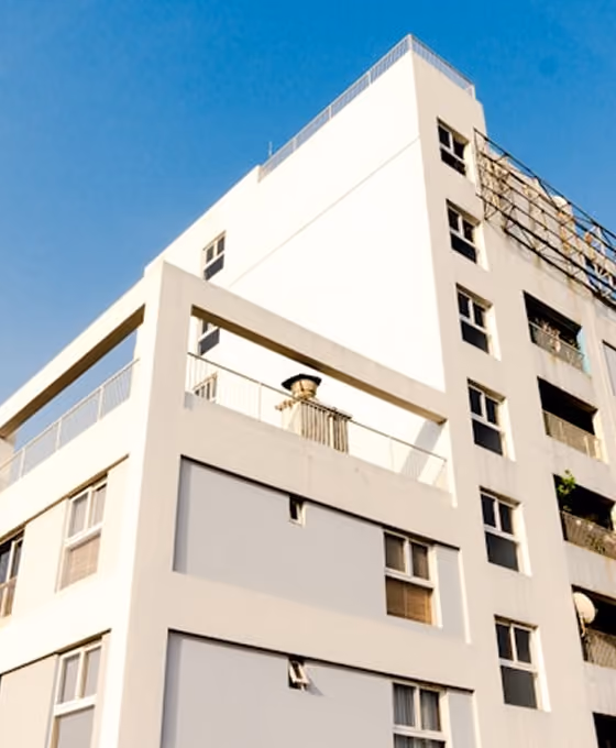 Bâtiment moderne blanc vu de bas avec ciel bleu en arrière-plan.