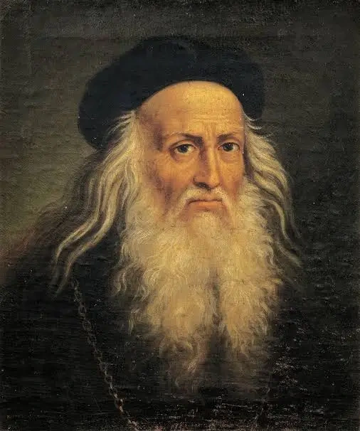 Portrait of an elderly man with long white hair and beard in dark clothing.