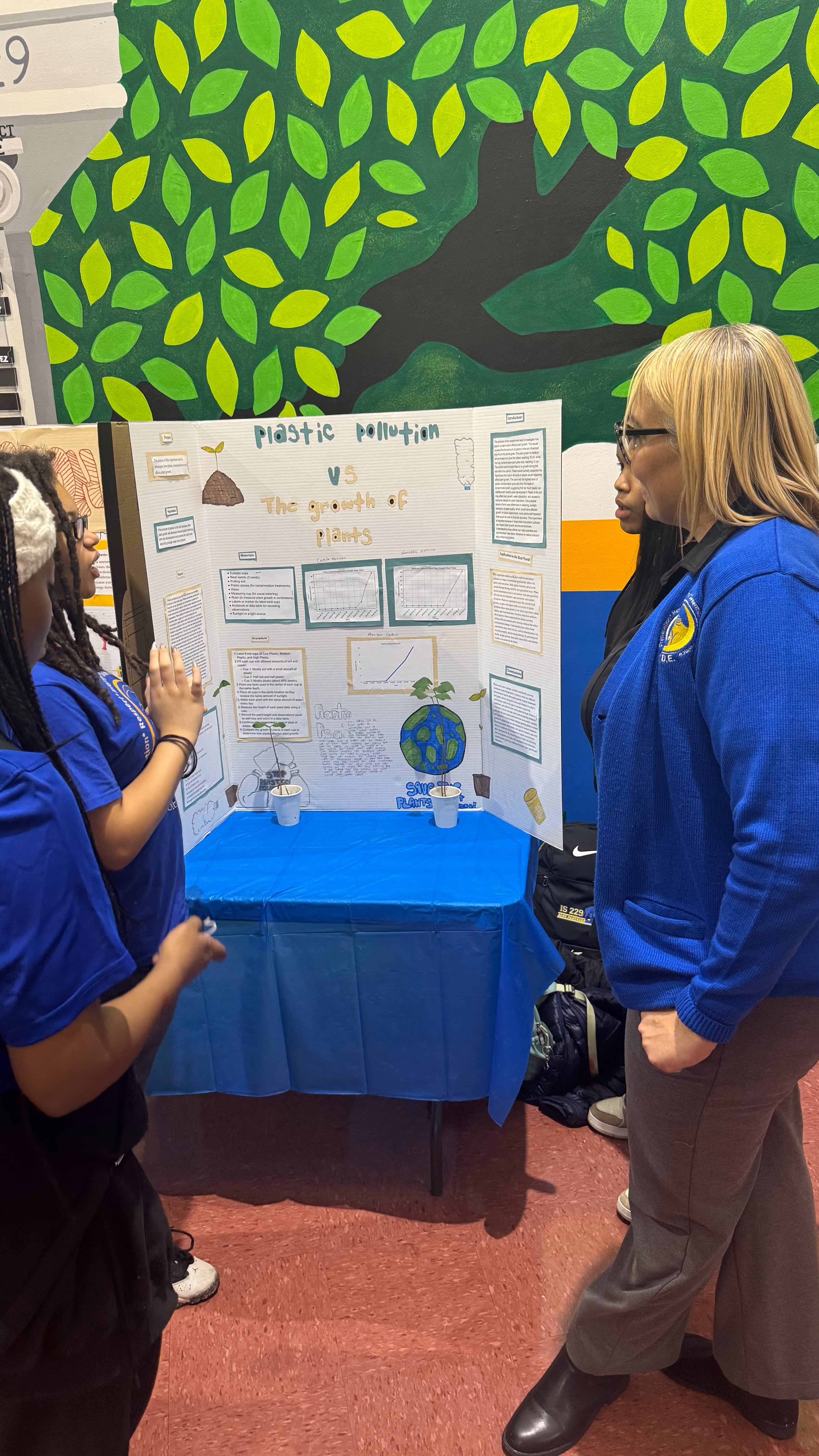 Student presents plastic pollution versus plant growth science fair project