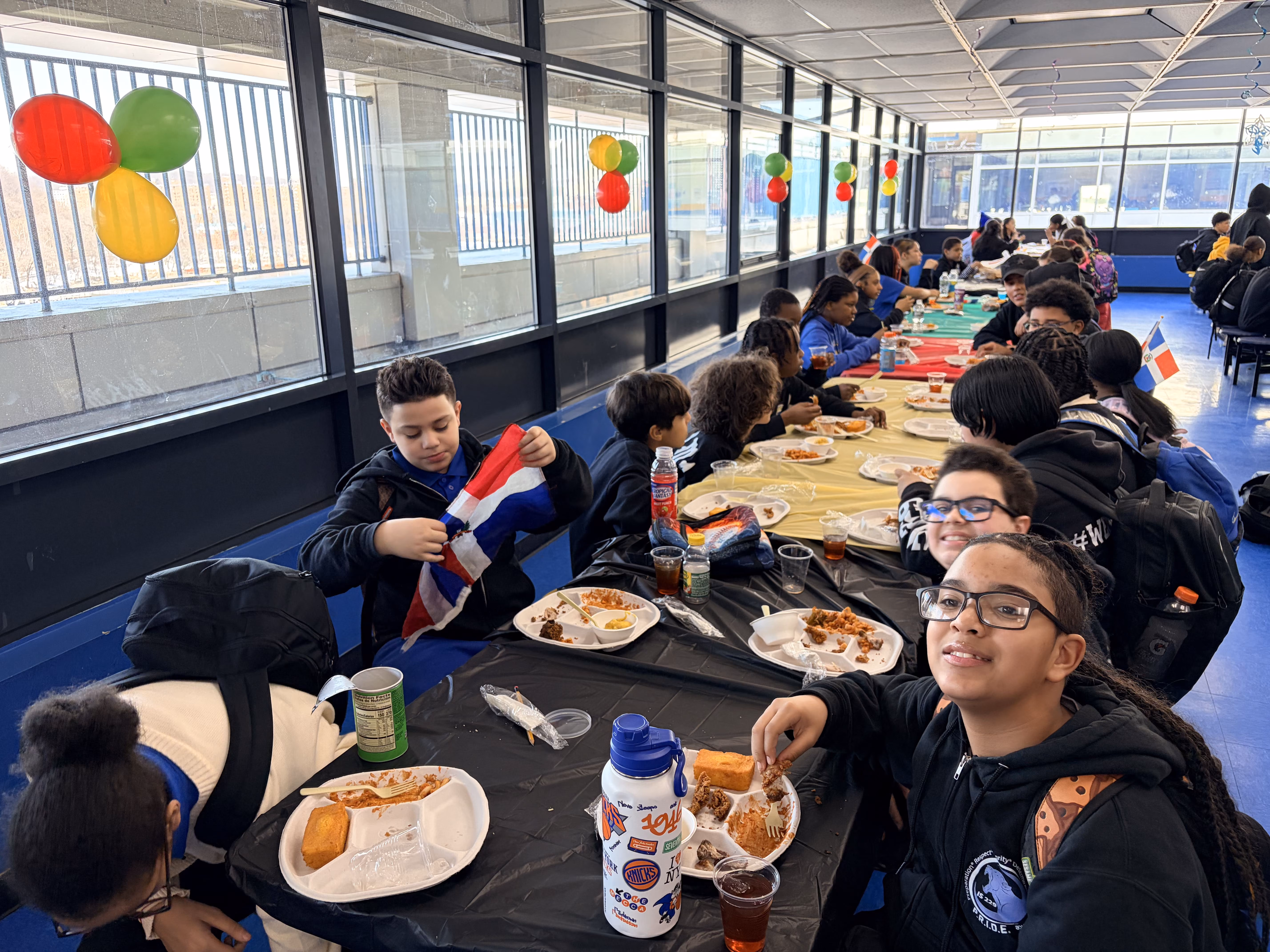 Students dining together at a school cultural celebration with colorful balloons