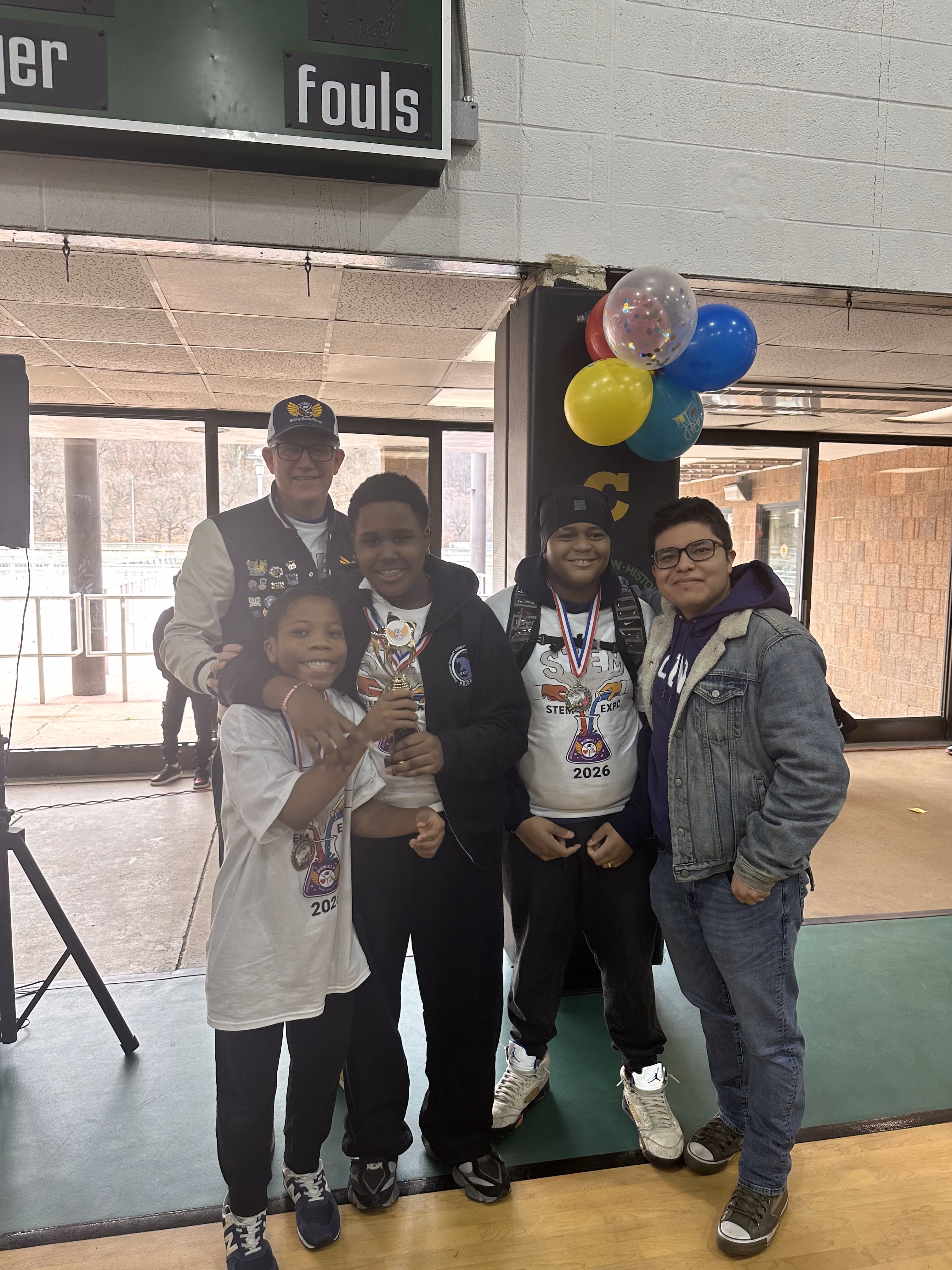 Students and adult posing with trophy and medals at STEM Expo