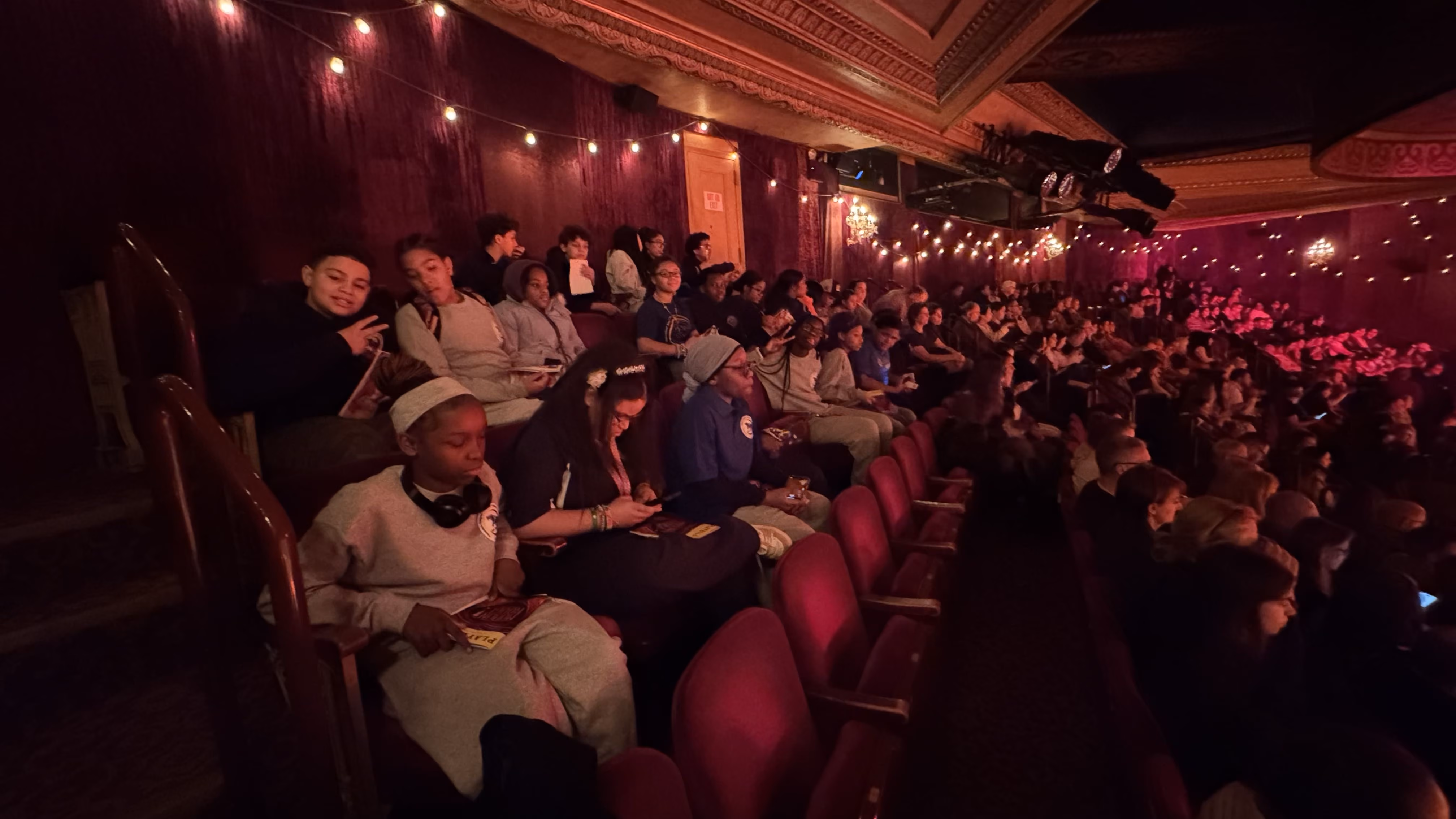 Students seated in a theater during a school field trip