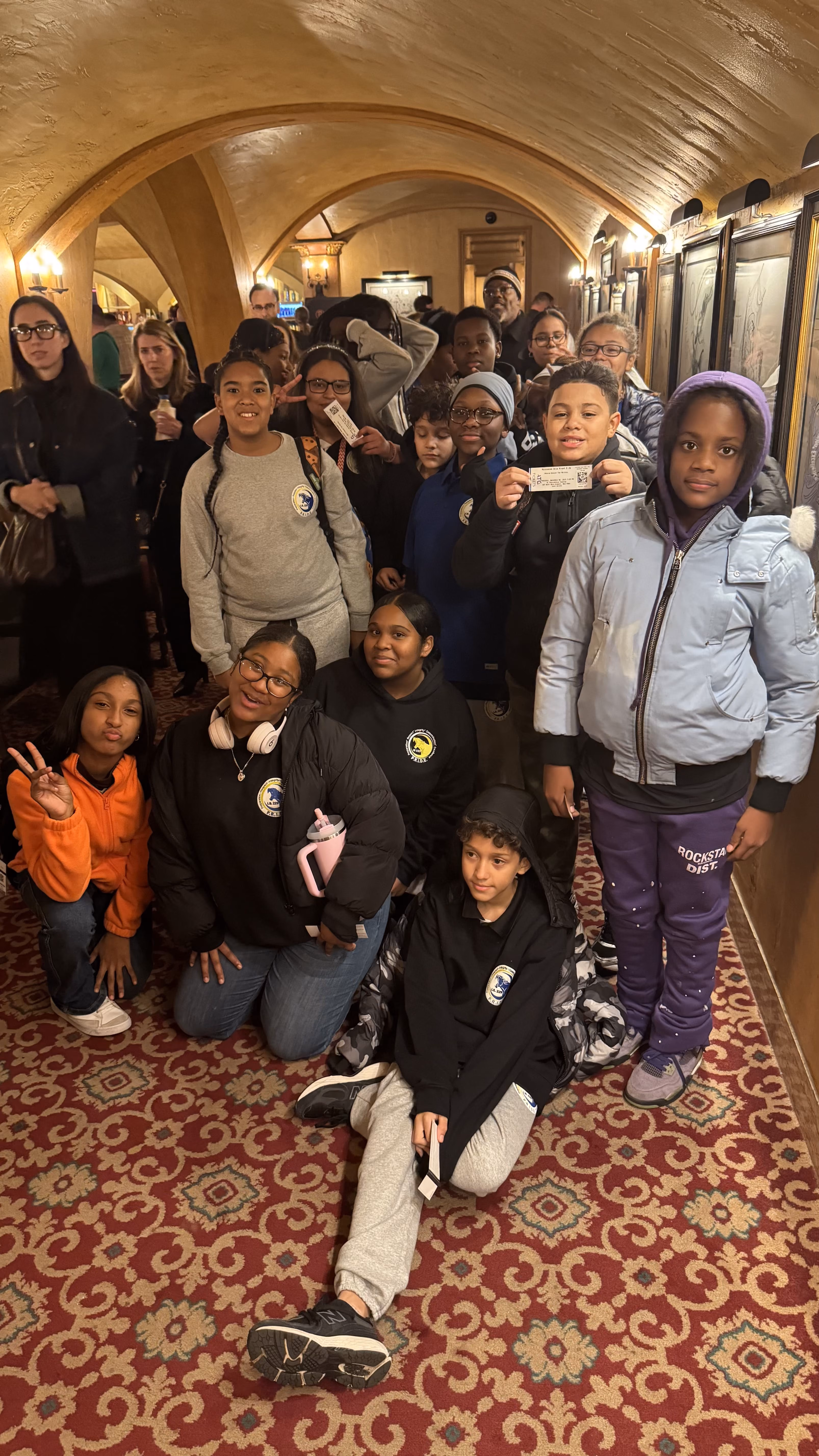 Students and chaperones posing inside a theater on a field trip