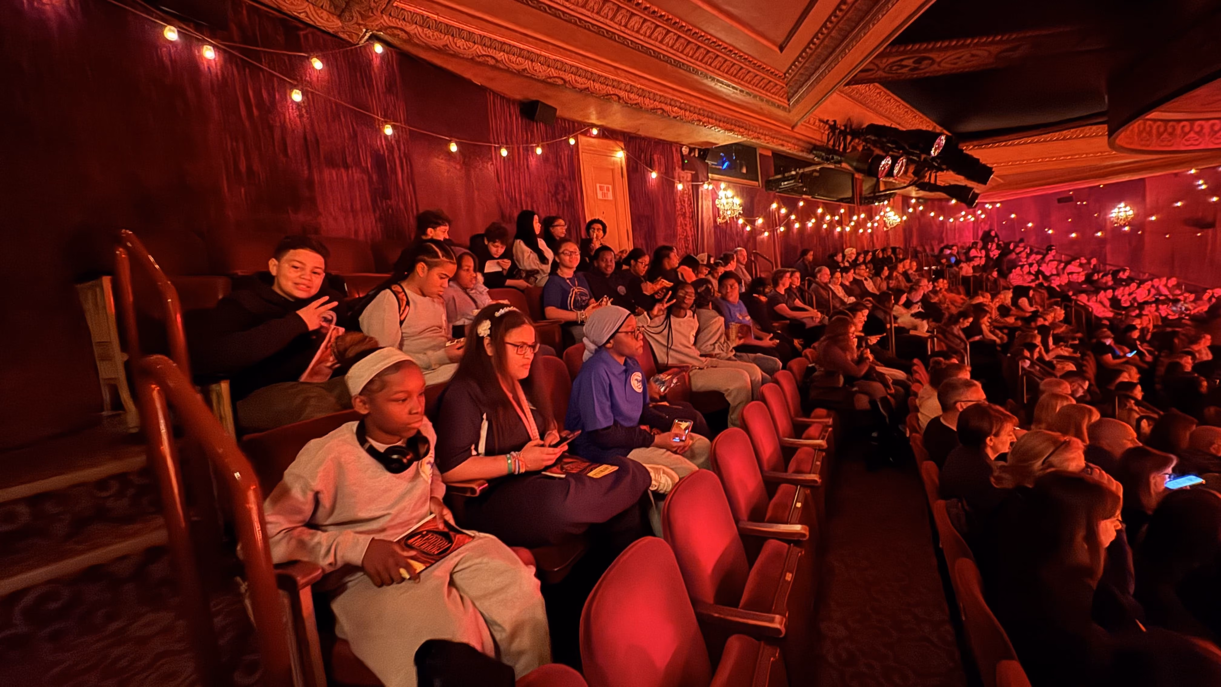 Students seated in a theater during a school field trip