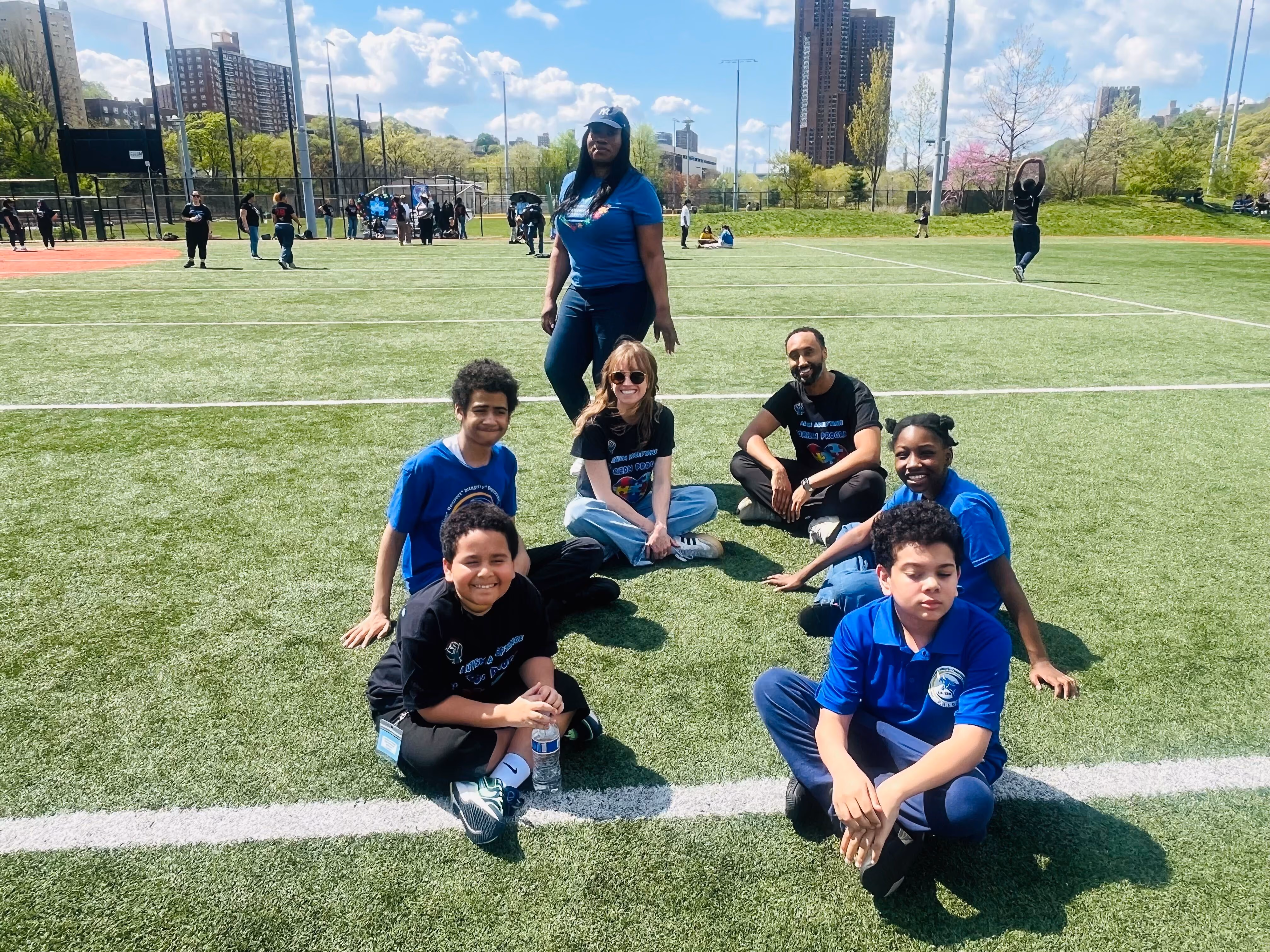 Students and staff pose together on outdoor turf field during school event